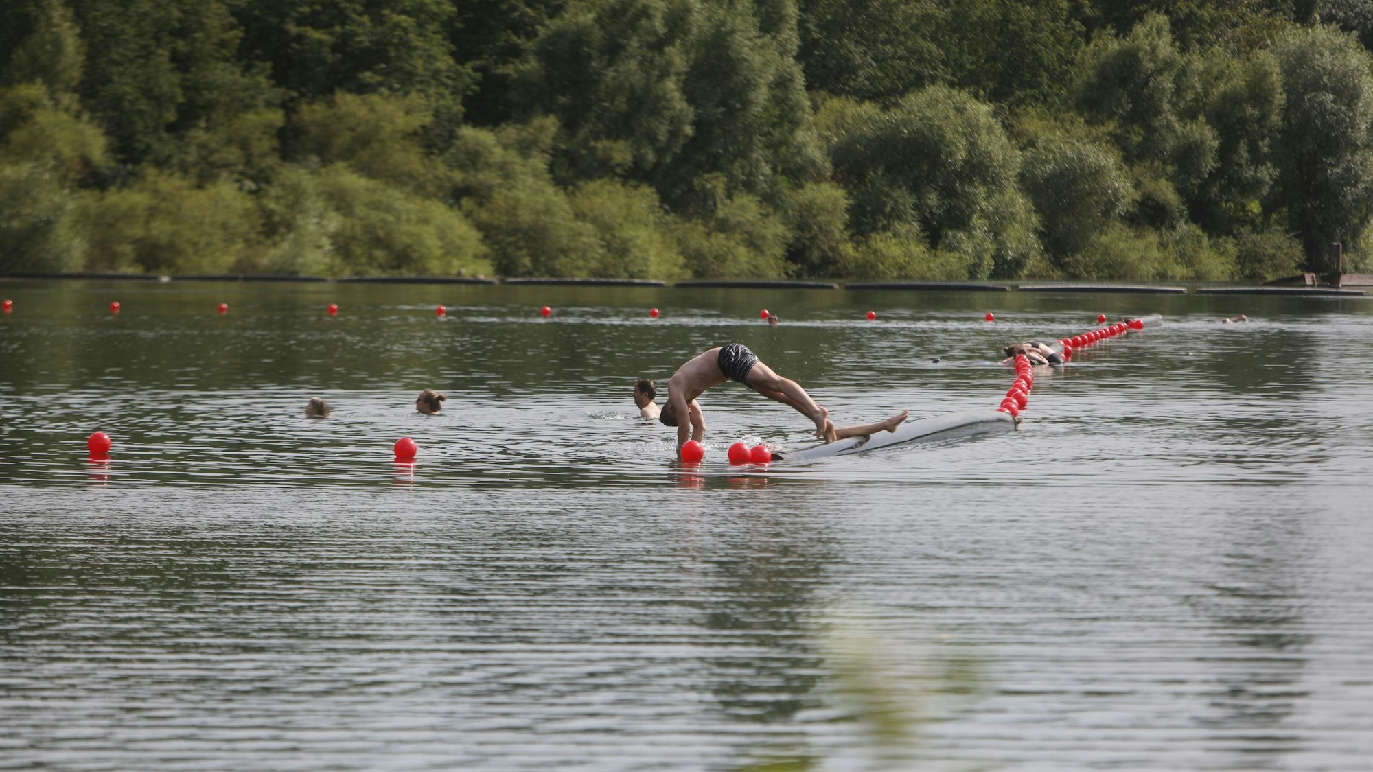 15.07.2024, Köln: Abkühlung am Fühlinger See. Ein paar Leute schwimmen im See.