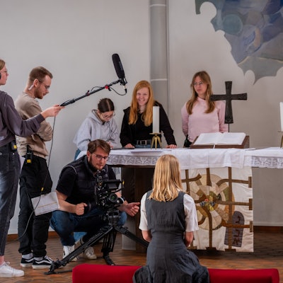 Vor dem Altar nimmt Lukas Kotthaus (hockend) gemeinsam mit seinem Team ein junges Mädchen auf.