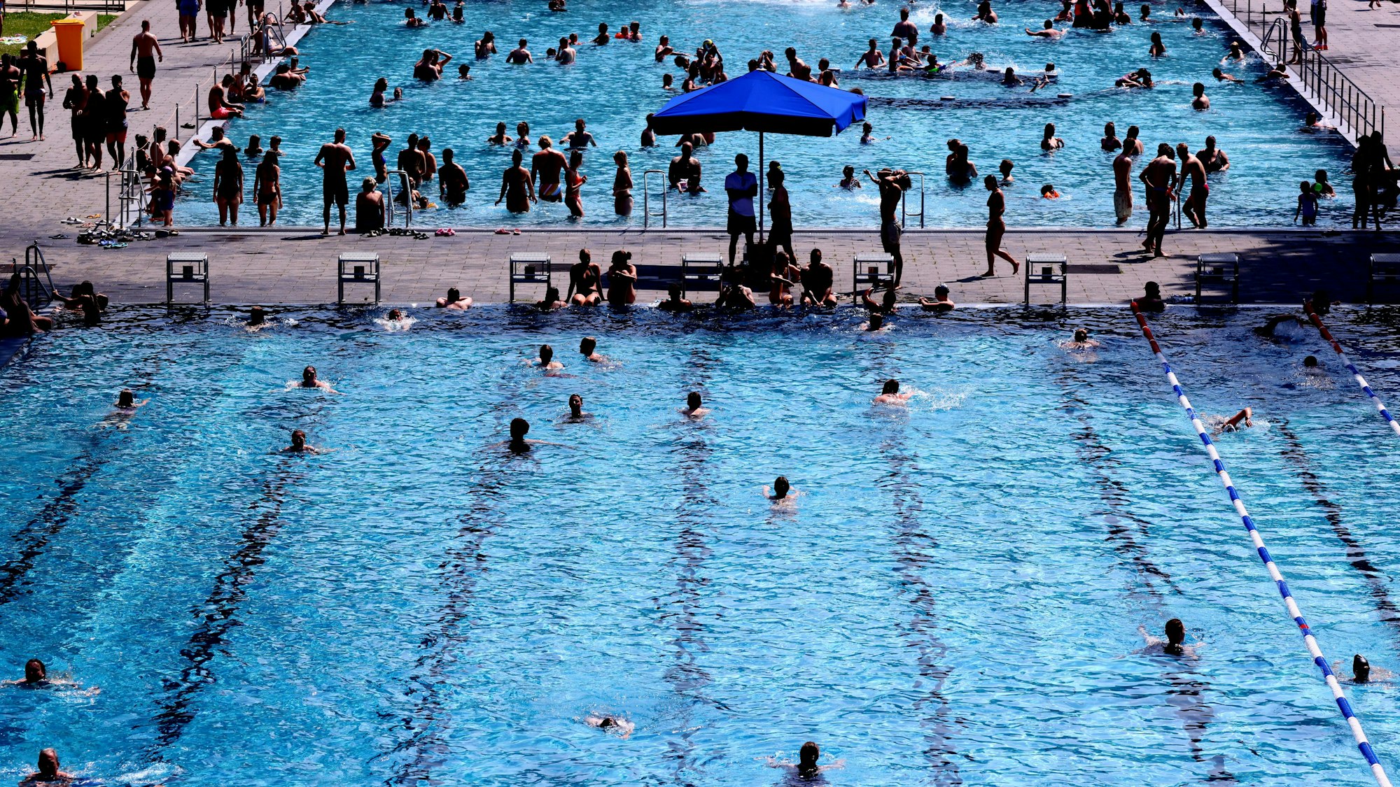 Menschen schwimmen im Stadionbad in Köln