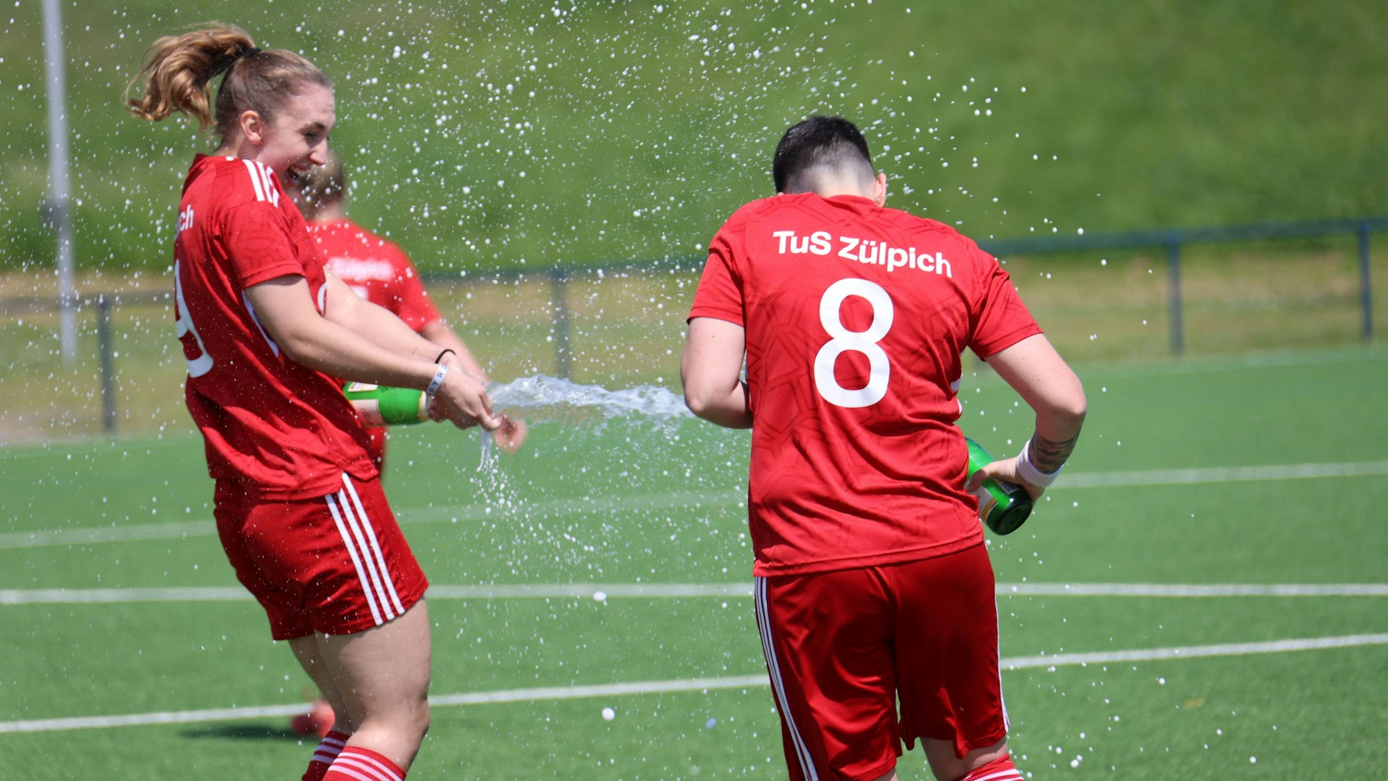 Julia Kurth und Christina Fischer feiern den Aufstieg 2024 standesgemäß, indem sie sich nassspritzen.