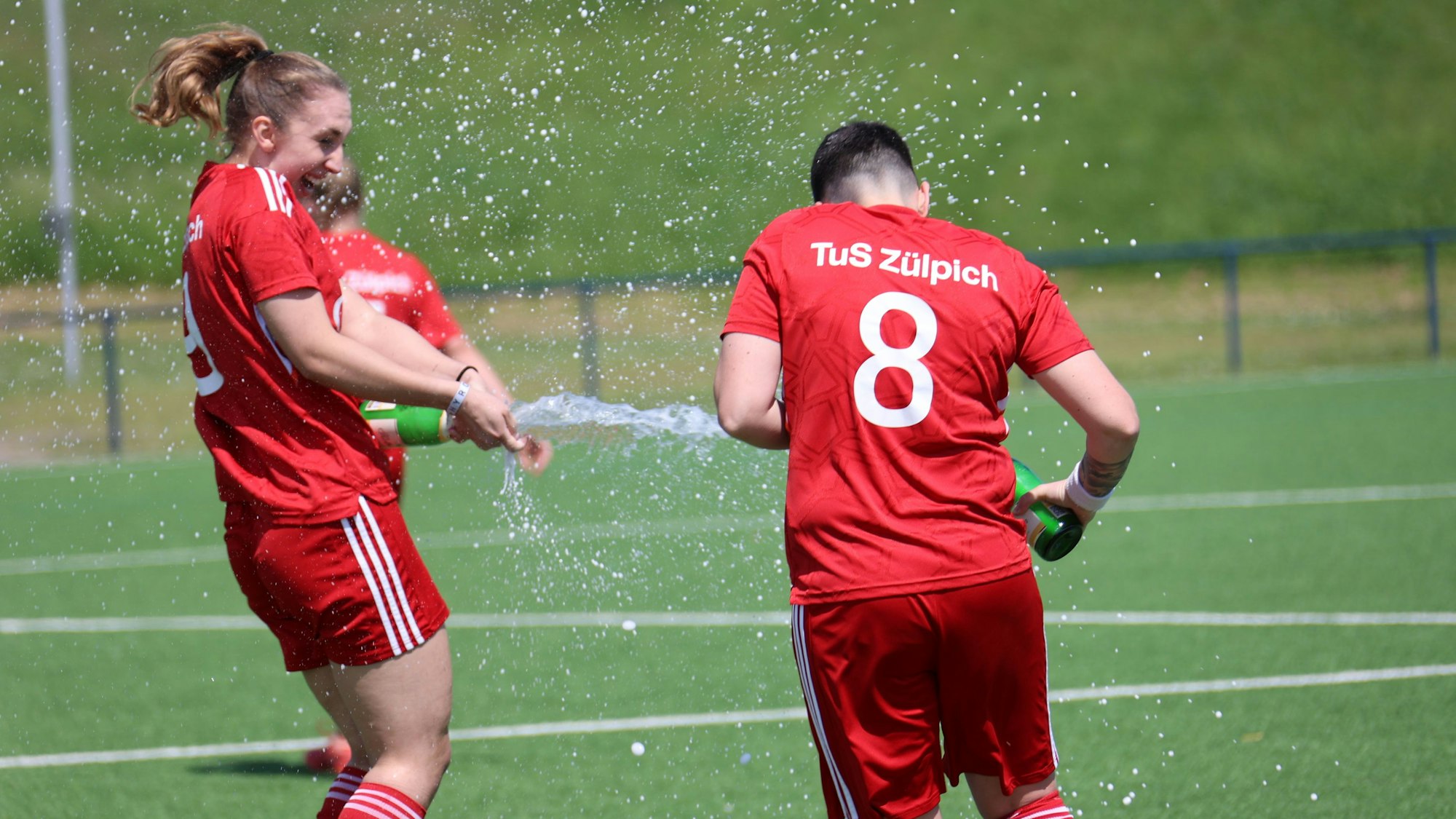 Julia Kurth und Christina Fischer feiern den Aufstieg 2024 standesgemäß, indem sie sich nassspritzen.