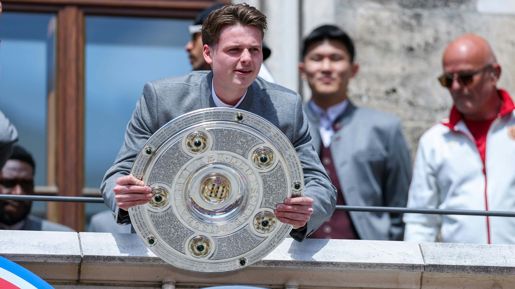 Jonas Urbig mit der Meisterschale auf der Meisterfeier des FC Bayern München.