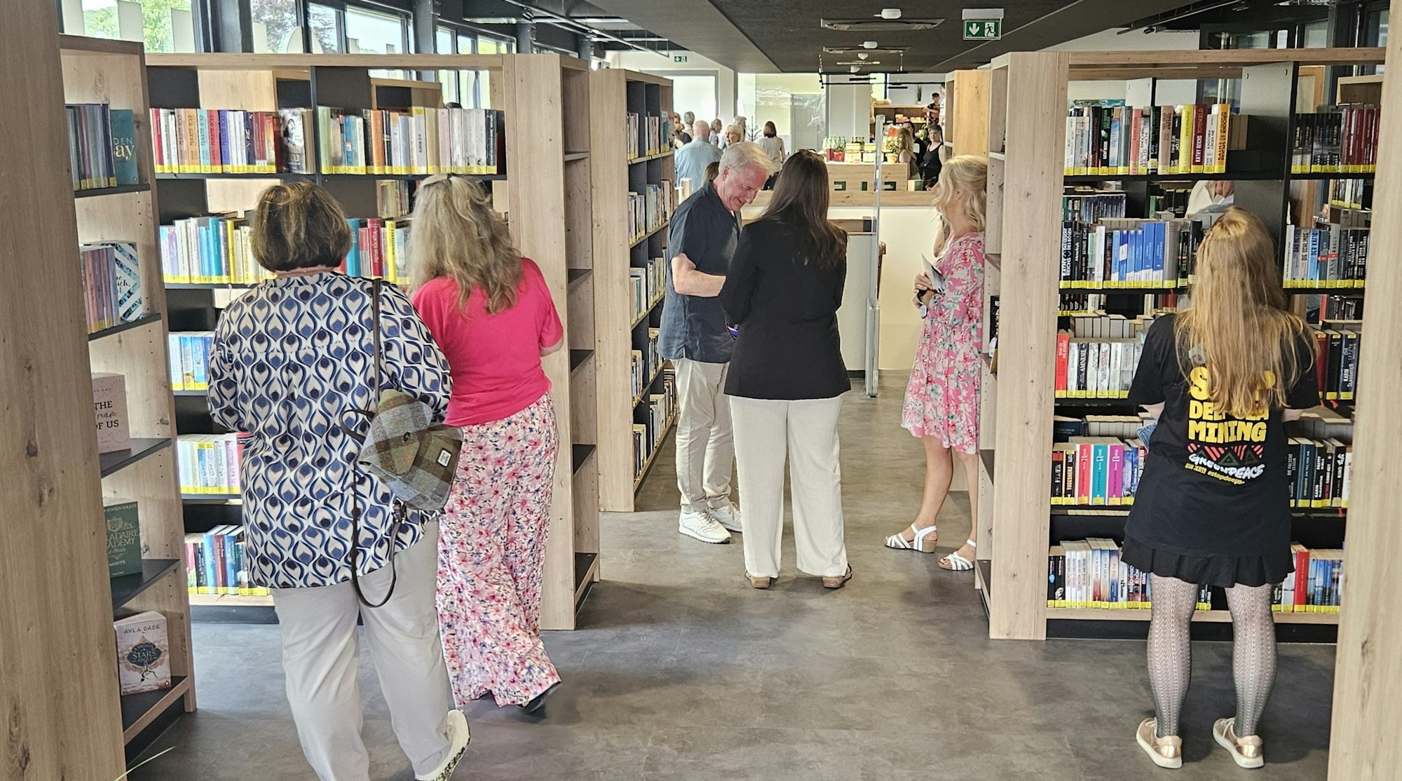 Blick auf die Regale mit den Büchern, vor denen einigen Personen stehen.