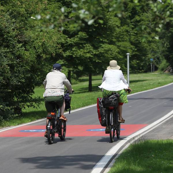 Zwei Radfahrerinnen auf einem gut ausgebauten Radweg.
