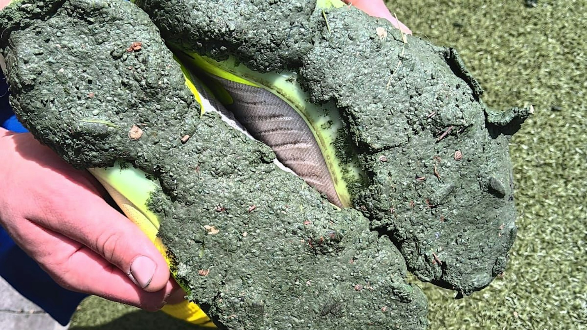 Auf dem Bild sind die Sohlen von Fußballschuhen zu sehen, die mit Granulat verschmolzen sind.