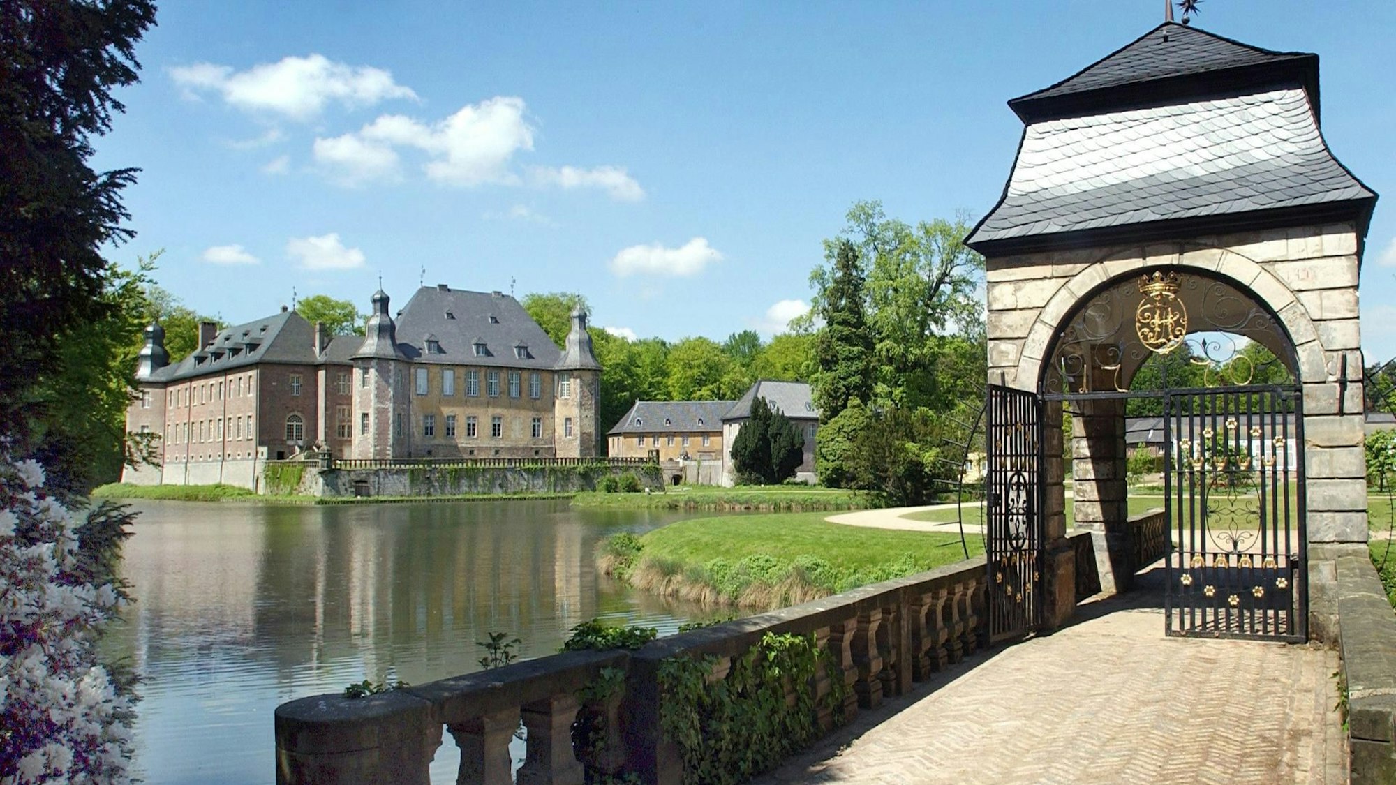 Blick auf eine Brücke in der Parkanlage von Schloss Dyck im niederrheinischen Jüchen mit dem Wasserschloss im Hintergrund. (Archivfoto)