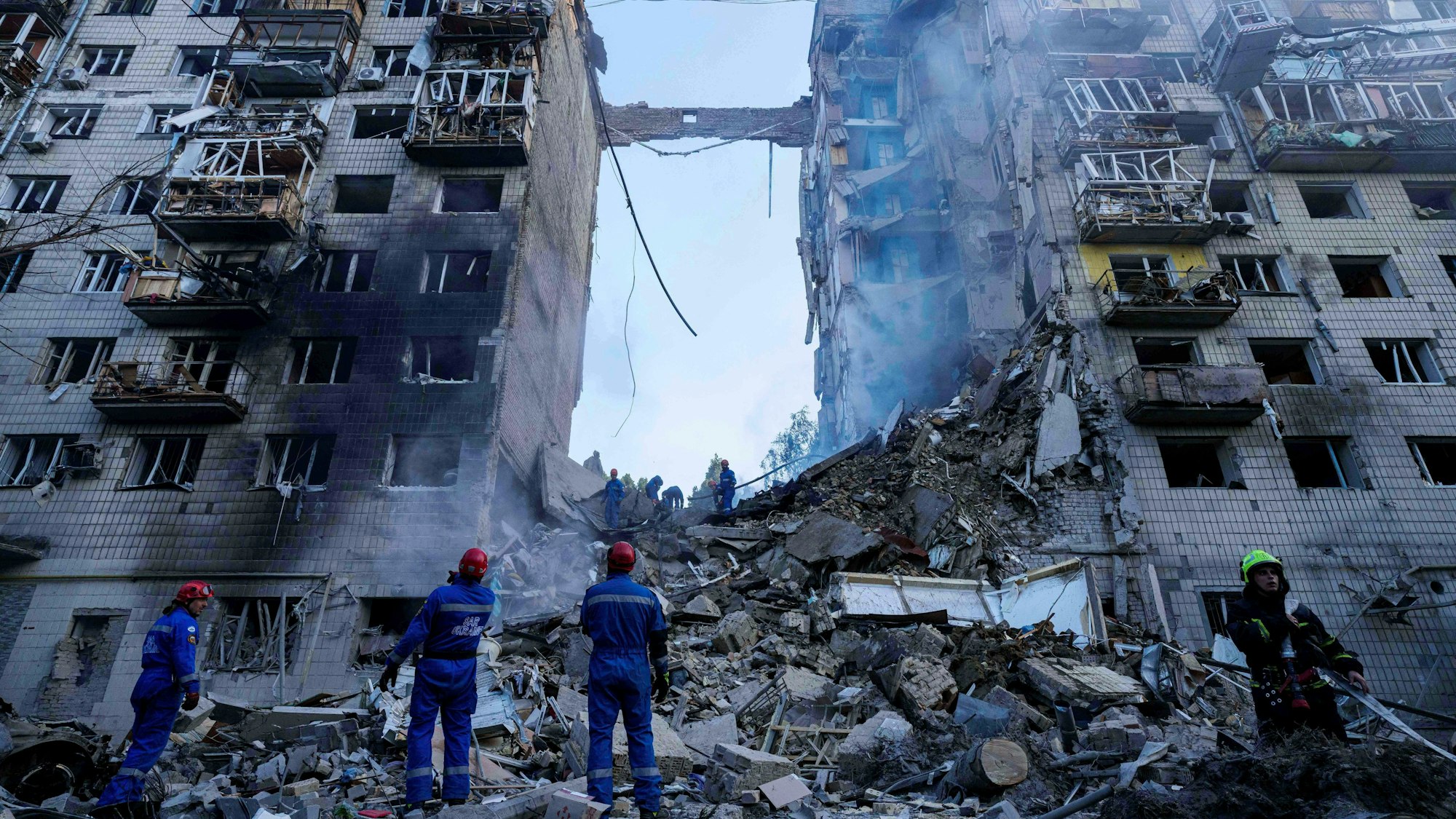 17.06.2025, Ukraine, Kiew: Rettungskräfte räumen die Trümmer an einem zerstörten mehrstöckigen Wohnhaus nach dem Einschlag einer russischen Rakete in der ukrainischen Hauptstadt. Foto: Evgeniy Maloletka/AP/dpa +++ dpa-Bildfunk +++