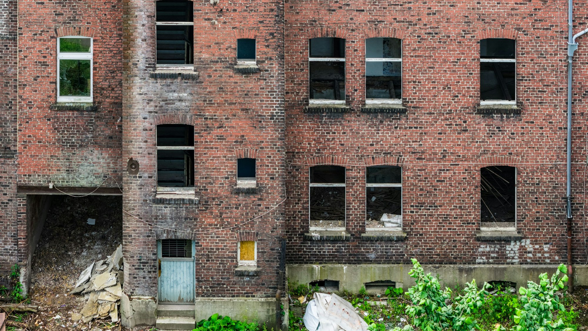 PRODUKTION - 09.06.2025, Nordrhein-Westfalen, Gelsenkirchen: Eine von sieben Problemimmobilien am Ahlmannshof, es fehlen zahlreiche Fenster im Haus. (Luftaufnahme mit einer Drohne) (zu dpa: «NRW will stärker gegen Schrottimmobilien vorgehen») Foto: Christoph Reichwein/dpa +++ dpa-Bildfunk +++