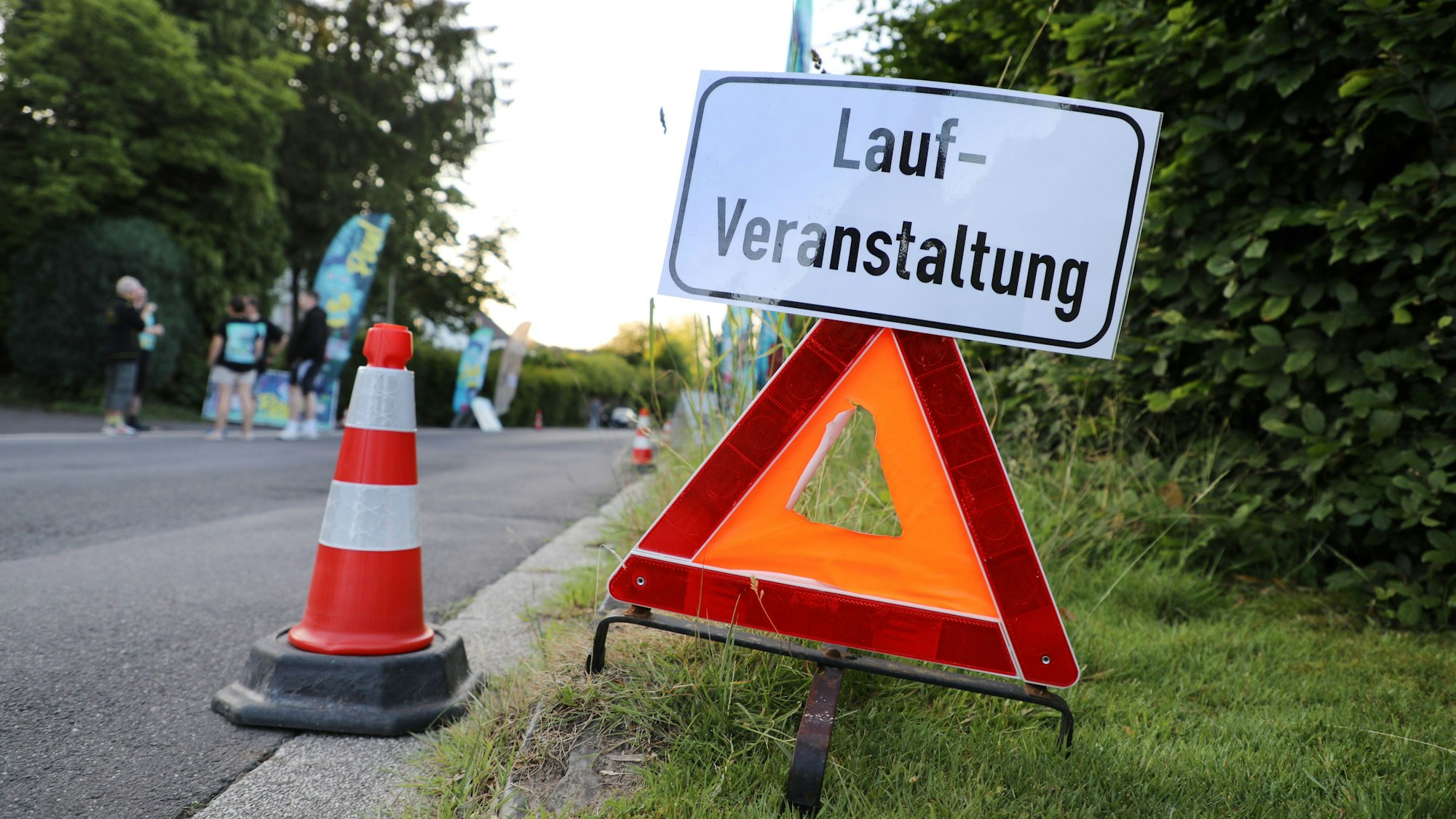 Ein Warndreieck mit einem Hinweisschild „Lauf-Veranstaltung“ steht am Straßenrand in Lindlar-Remshagen.