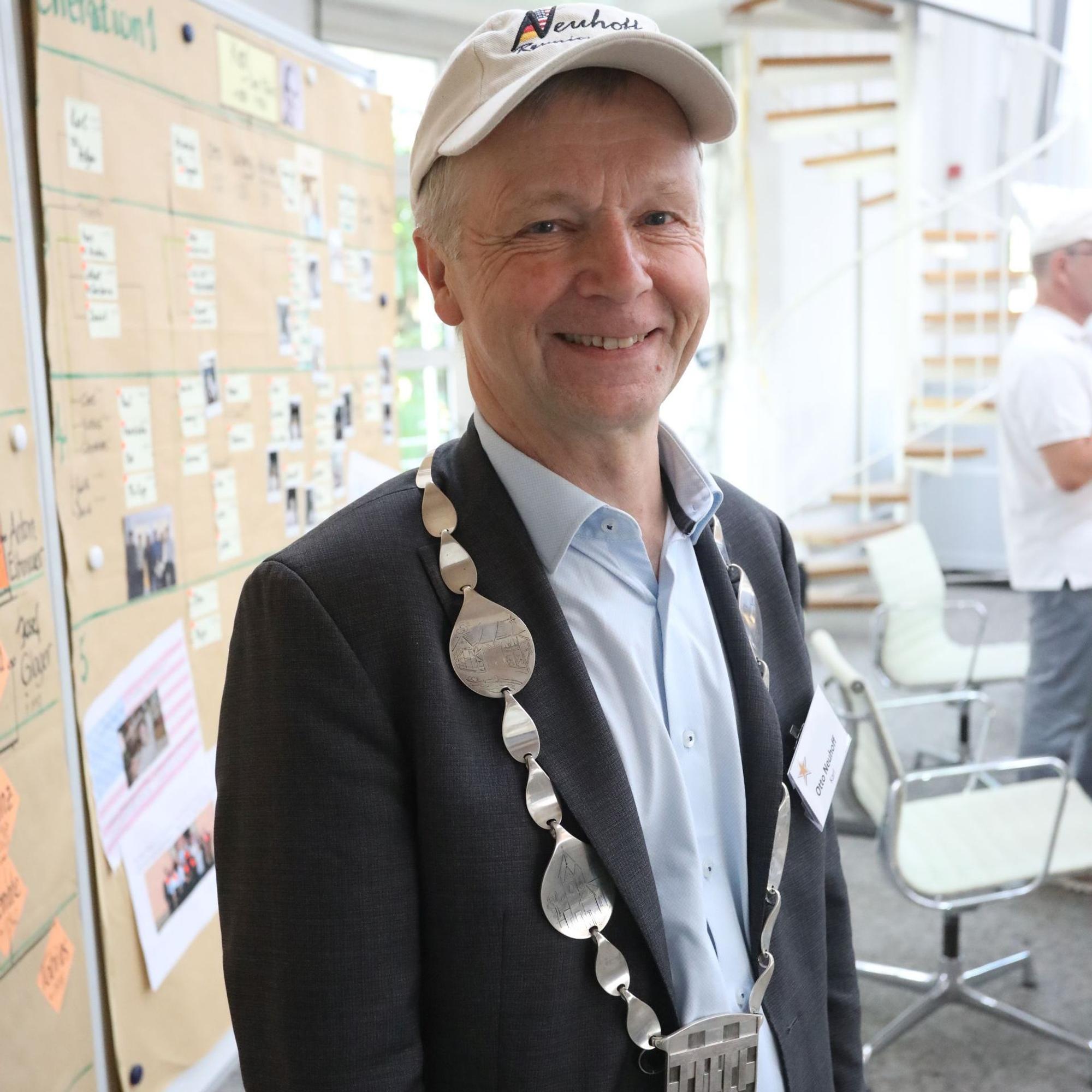 Bad Honnefs Bürgermeister im Ratssaal, im Hintergrund eine Stellwand mit Stammbäumen.