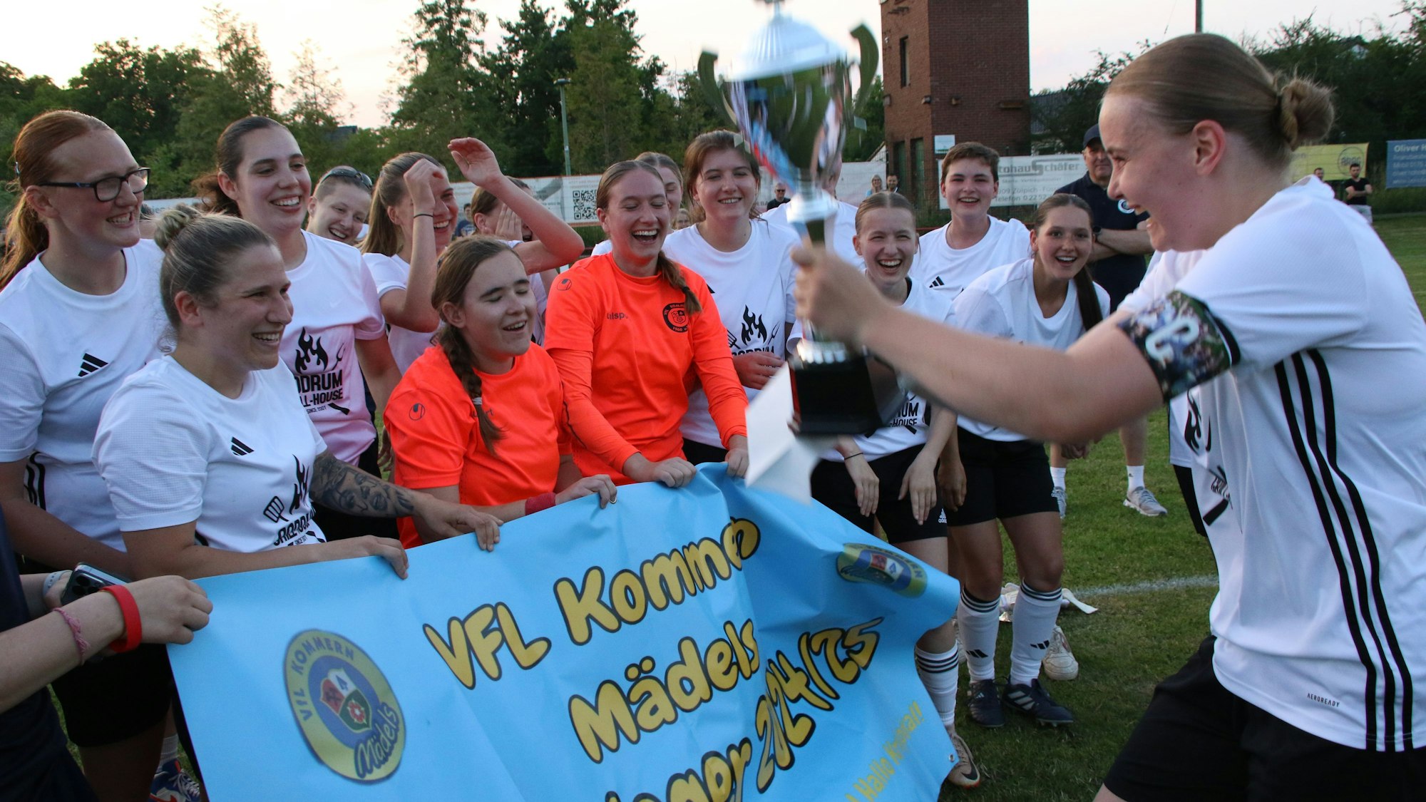 Kommerns Kapitänin Nele Wagner (r.) präsentiert den Kreispokal ihren jubelnden Mitspielerinnen.