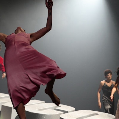 Mehrere Schwarze Tänzer in Abendgarderobe und Seidenkleidern.