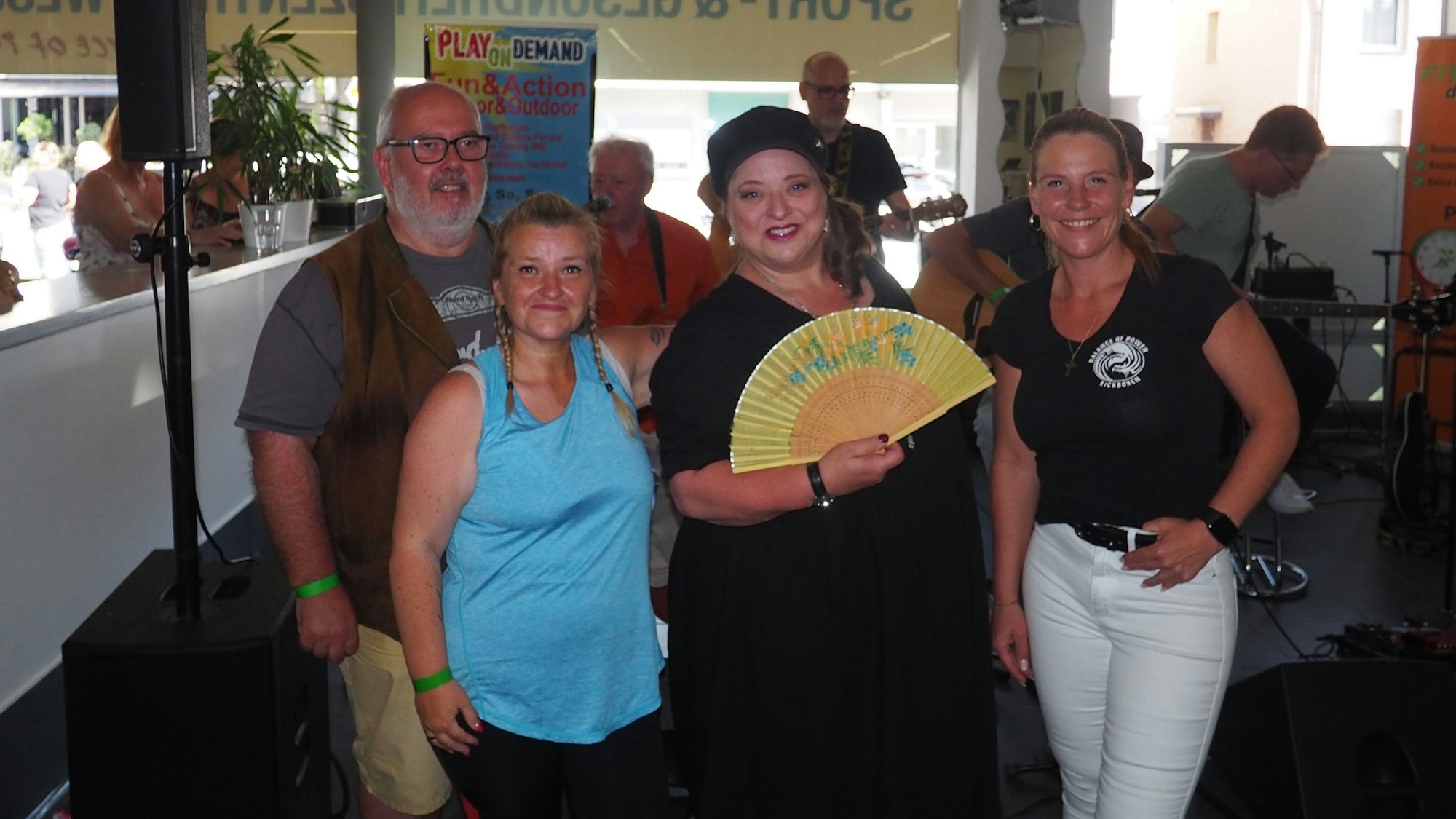 Auf dem Bild sind drei Frauen und ein Mann bei einem Benefizkonzert zu sehen.