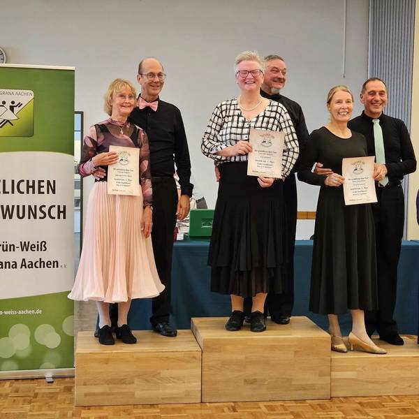 Uwe und Vera Bartsch stehen auf dem Podium ganz oben. Vera Bartsch hält die Urkunde in die Kamera.
