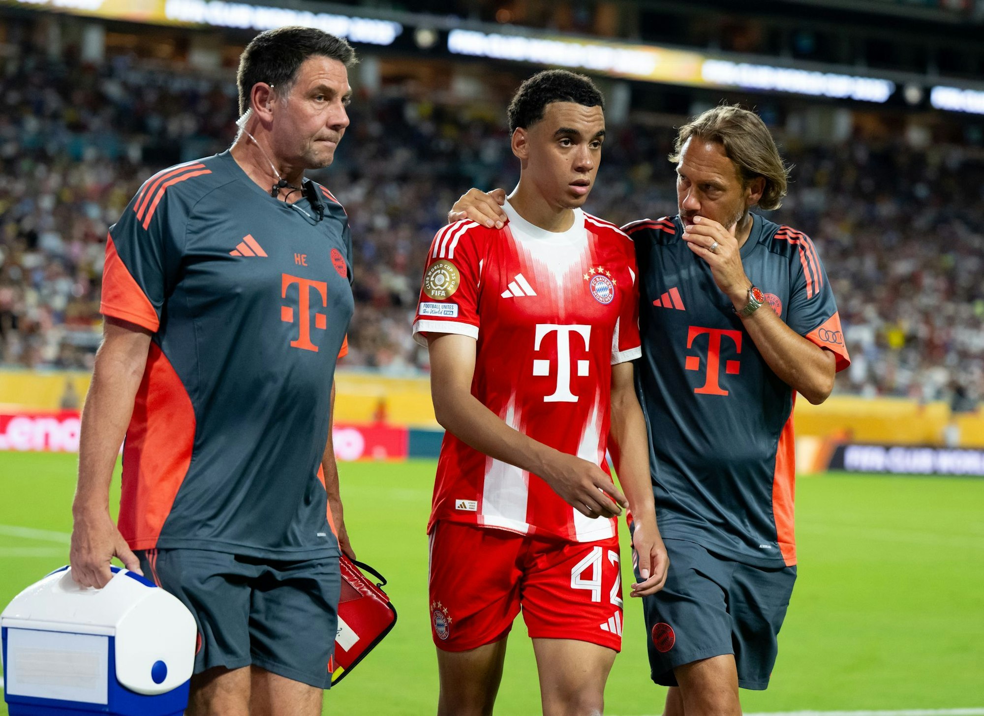 Jamal Musiala musste nur 25 Minuten nach seiner Einwechselung angeschlagen vom Platz, begleitet von Teamarzt (r) und Physiotherapeut.