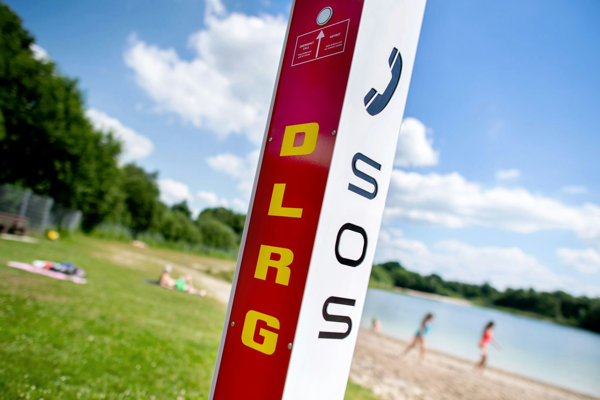 Eine Notrufsäule der DLRG steht an einem Badesee. In Köln geriet ein Dreijähriger am Samstag unter Wasser und starb. (Symbolfoto)