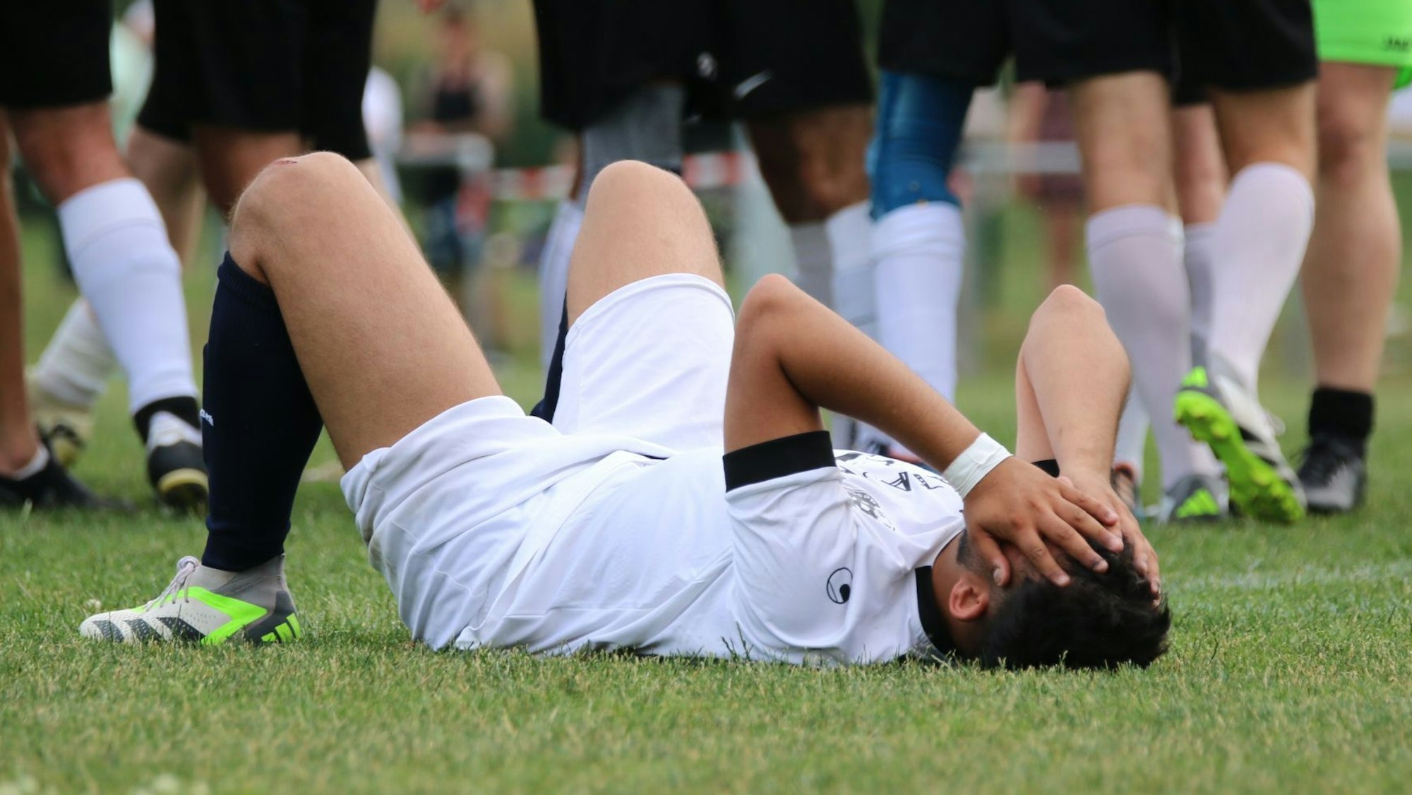 Ein Spieler des SV Bessenich liegt nach dem verlorenen Endspiel auf dem Boden und hat sich die Hände vors Gesicht geschlagen.