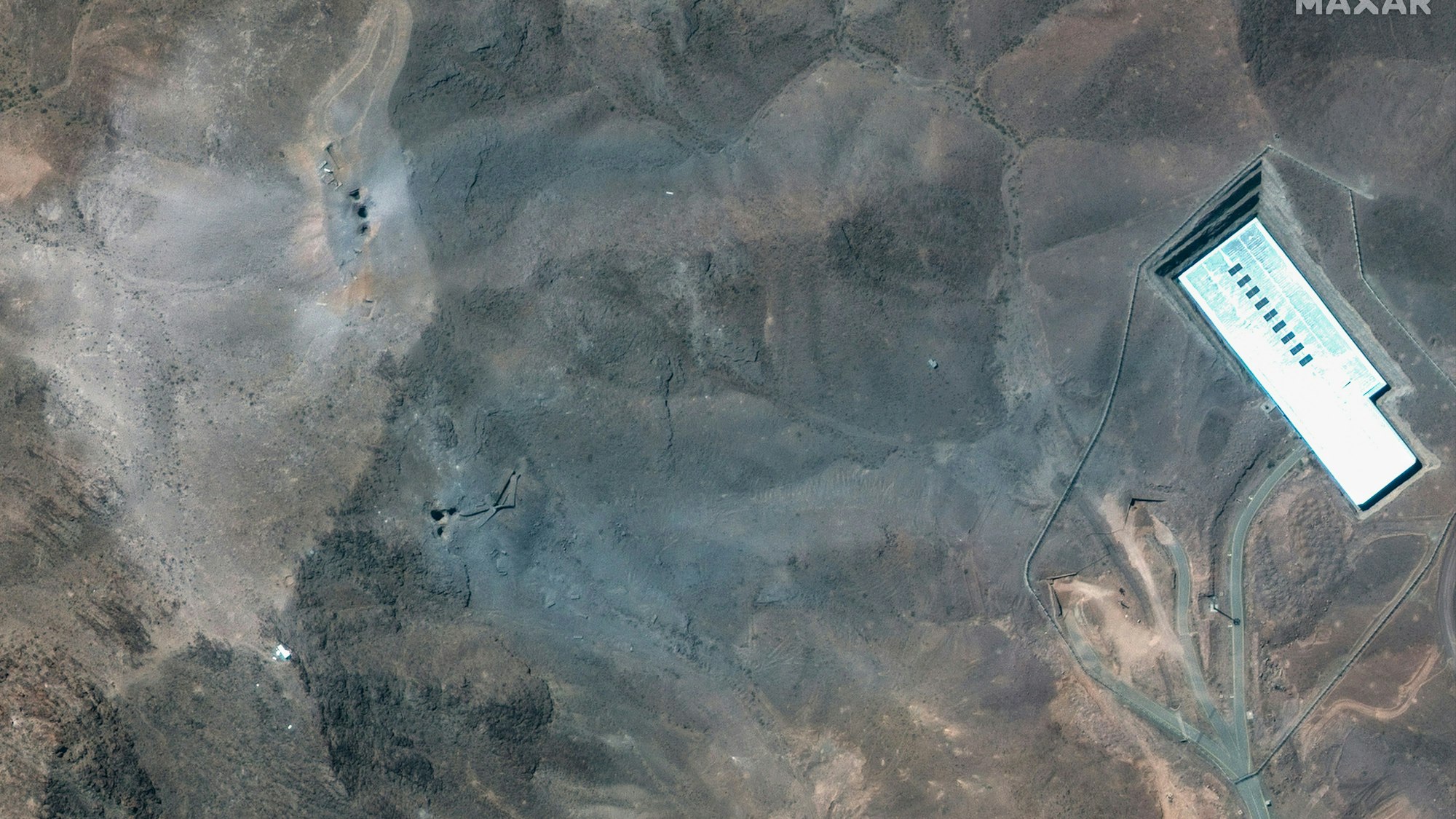 Dieses von Maxar Technologies zur Verfügung gestellte Satellitenbild zeigt eine Nahaufnahme von Kratern und Asche auf einem Hügel bei der Anreicherungsanlage Fordo im Iran nach den US-Angriffen am 22. Juni 2025.