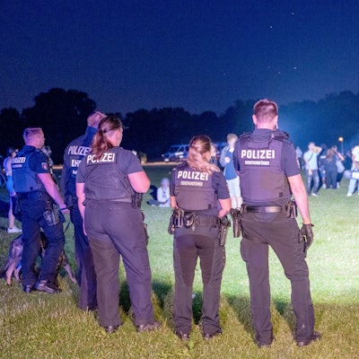 Einsatzkräfte der Polizei und Jugendliche stehen sich im Hamburger Stadtpark gegenüber.