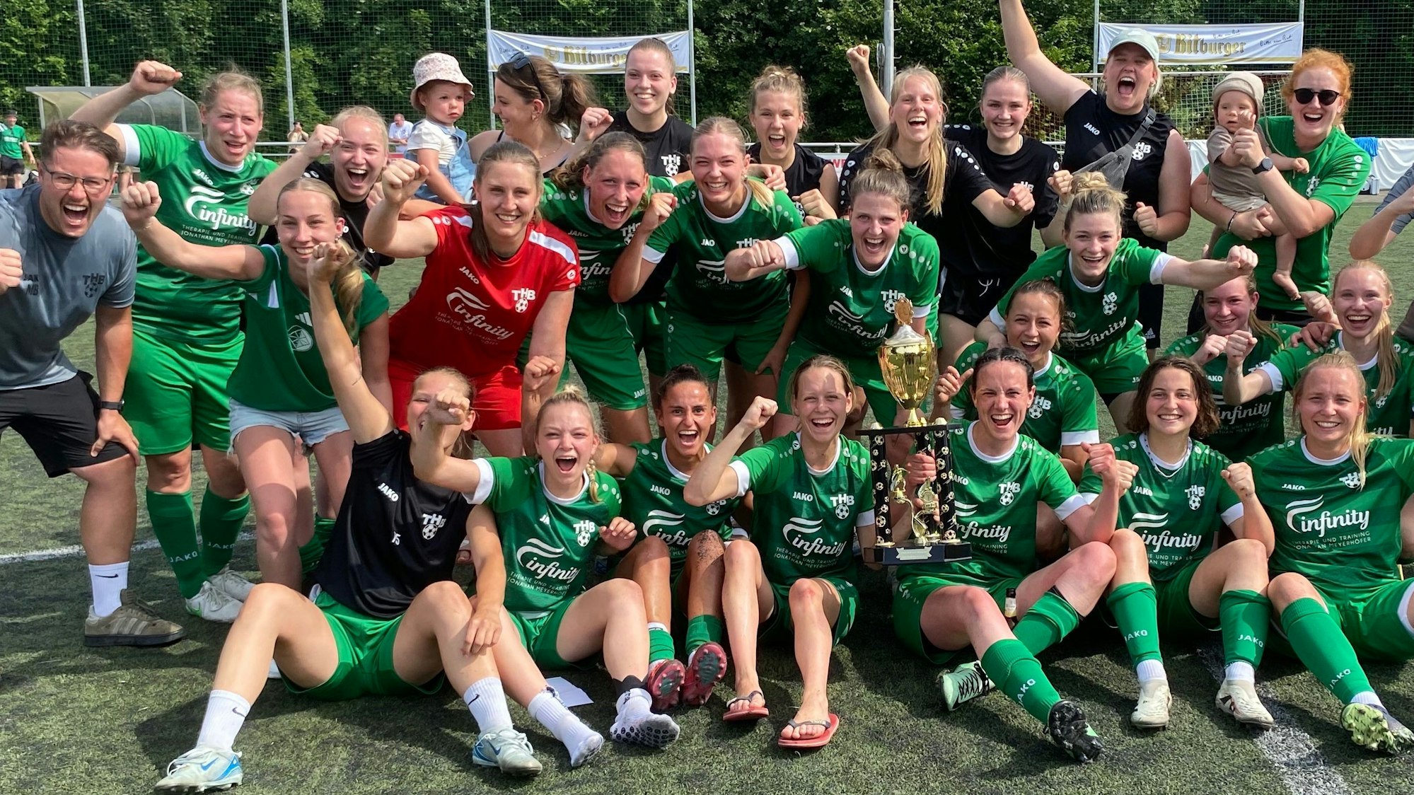 Die Fußballerinnen und das Trainerteam jubeln mit dem Pokal .