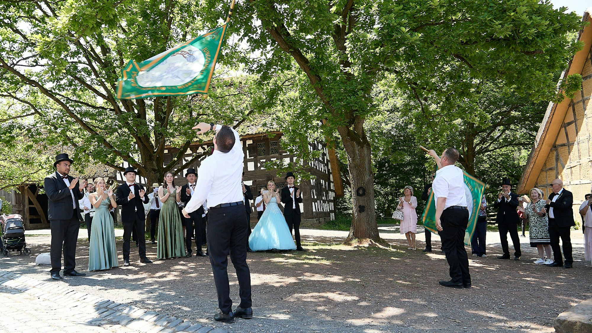 Das Bild zeigt einen Moment der Feierlichkeiten im Museum. Zwei Männer schwenken Fahnen.