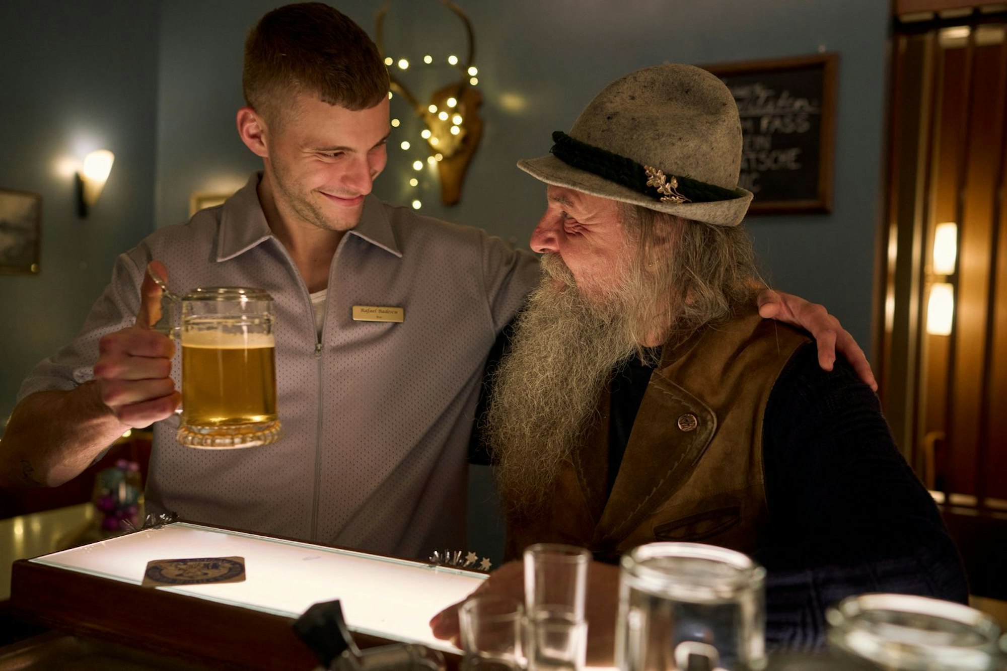 Rafael (Ben Felipe, links) erweist sich als naiver Barkeeper, der meist leeren Hotelbar. Außer Stammgast Gandalf (Uwe Jannaschk) besucht selten jemand die Bar. (Bild: ZDF/ Frank Dicks)