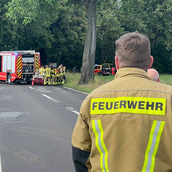 Einsatzkräfte der Feuerwehr an der Unfallstelle auf einer Landstraße (Archivfoto).