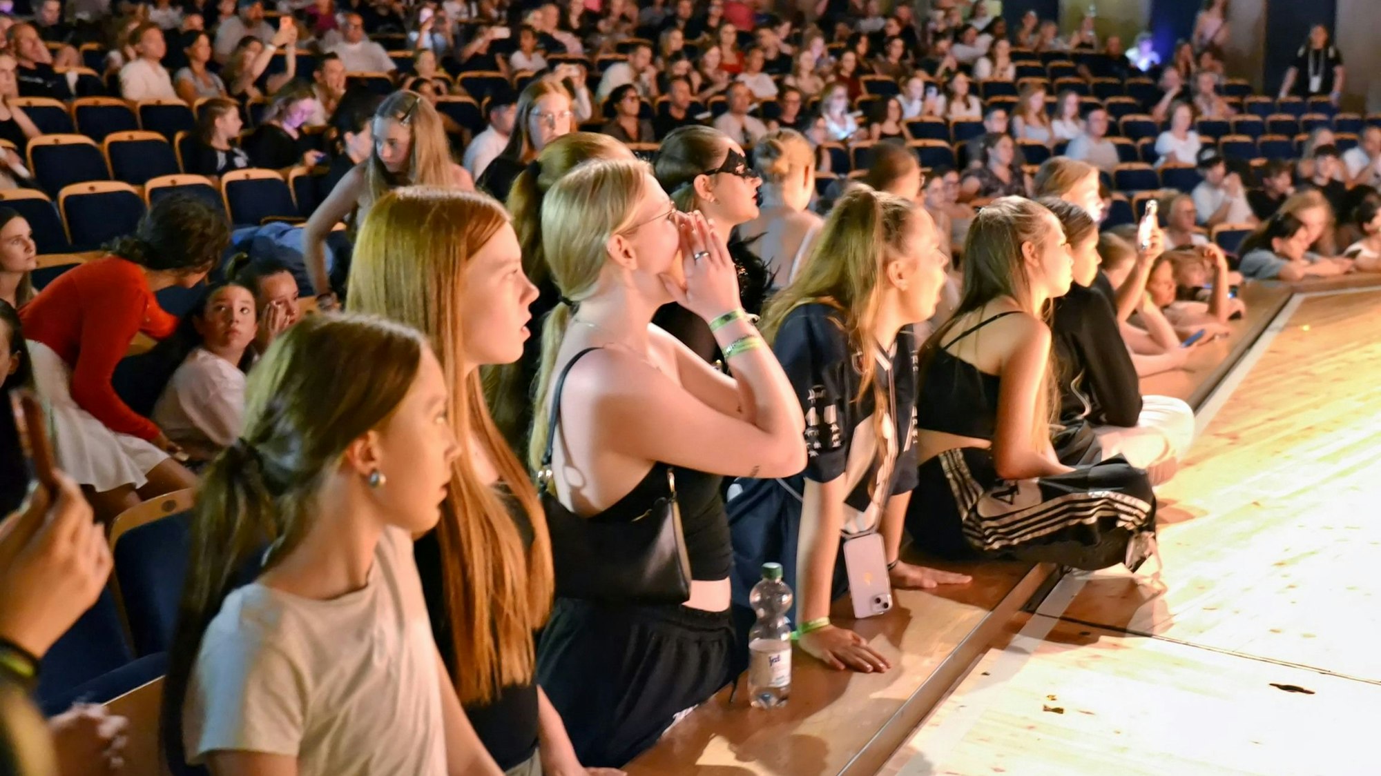 Am Rande der Bühne des Stadttheaters stehen Fans und schauen gebannt zu oder feuern die Tänzerinnen und Tänzer an.
