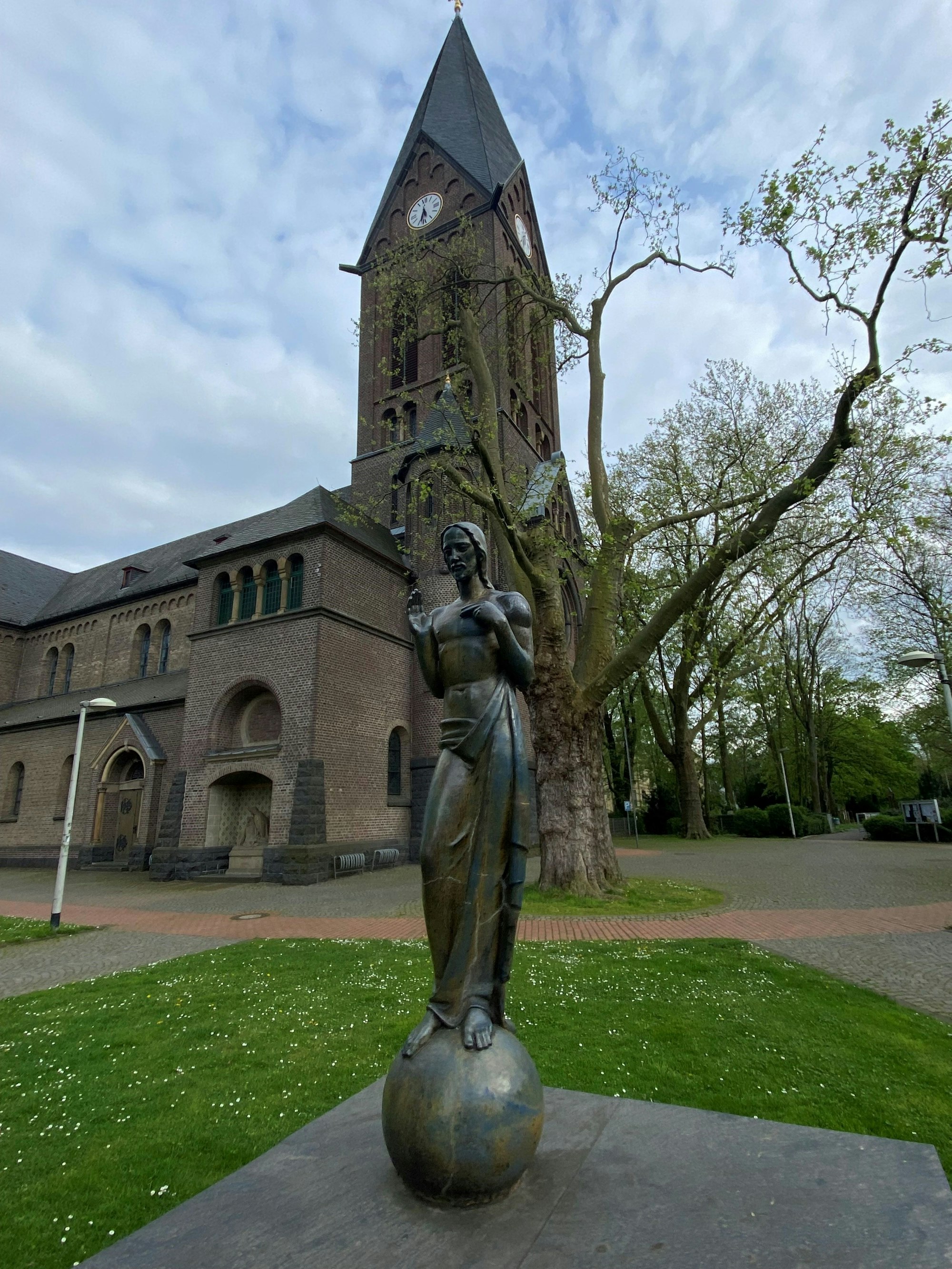 Auf dem Bild ist eine Skulptur vor einer Kirche zu sehen.
