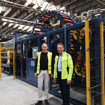 Die Geschäftsführer der Firma Schoeller, Alexander Mertens (l.) und Michael Gottschalk, stehen vor der insgesamt fast 100 Meter langen Laserschweißanlage, die in Hellenthal installiert wurde.