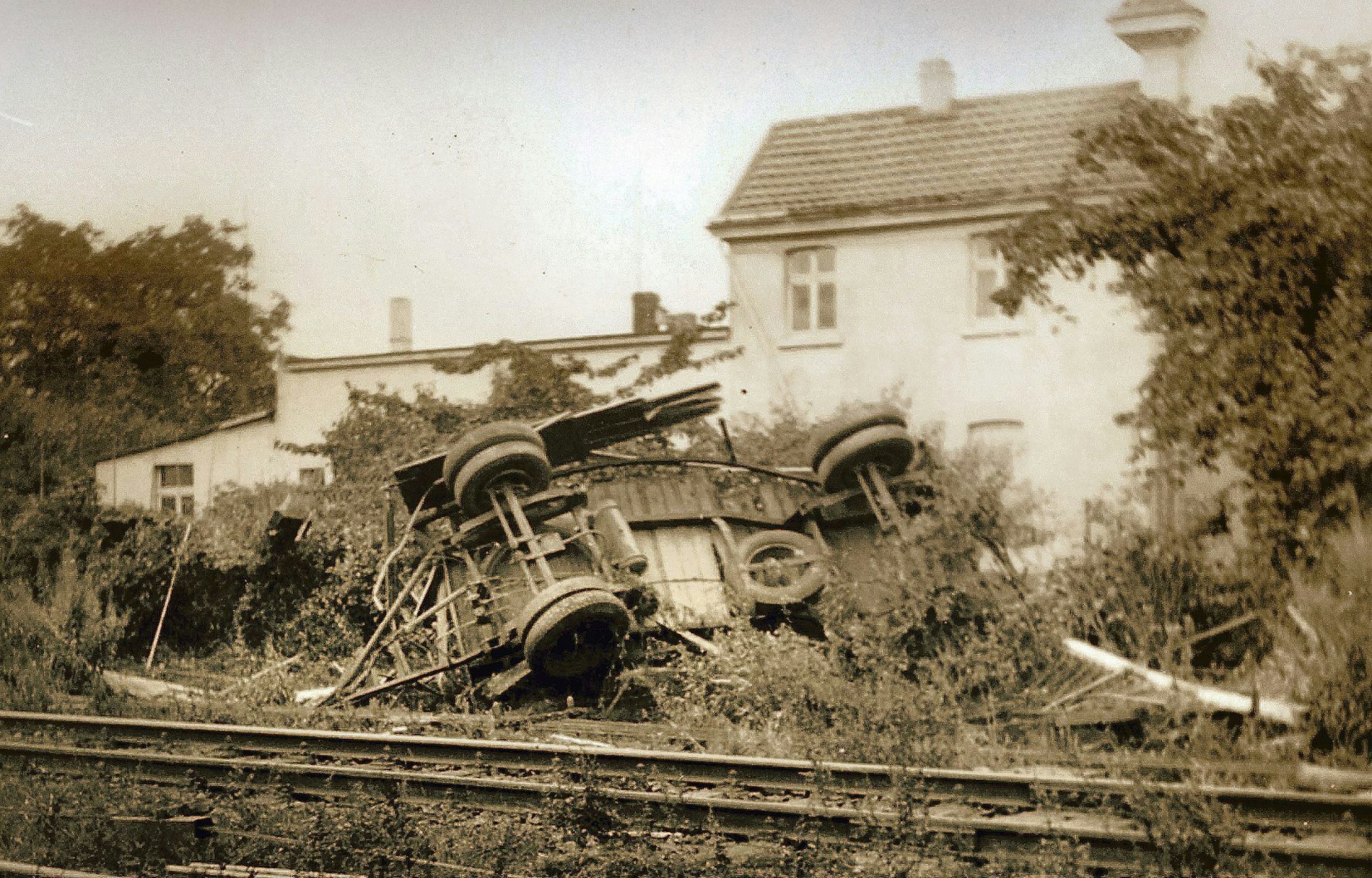 Ein umgestürzter Lkw liegt neben einem Bahngleis.