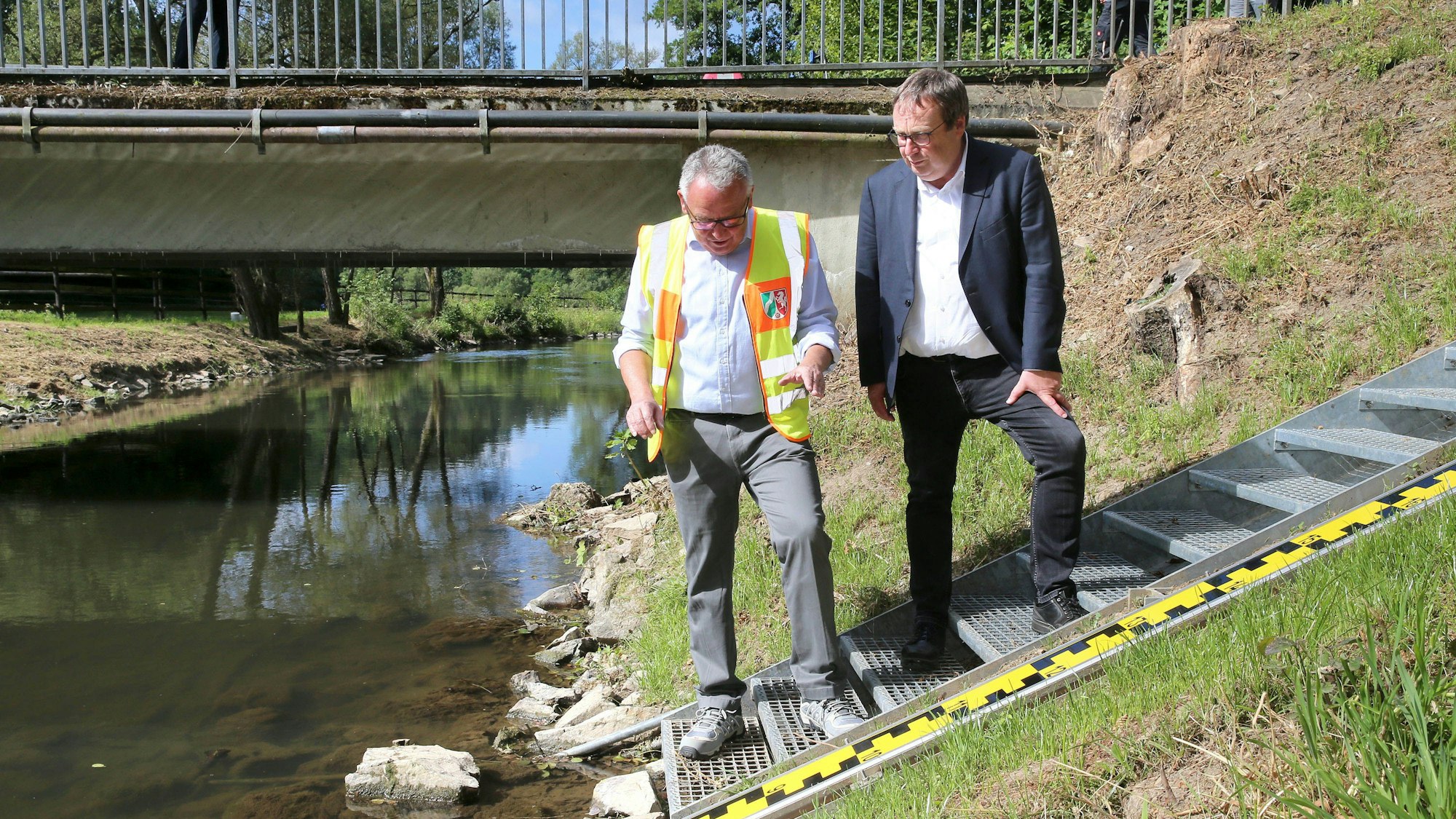 Roland Funke vom Landesumweltamt erläutert NRW-Umweltminister Oliver Krischer die Technik am neuen Hochwasserpegel in Lindlar.