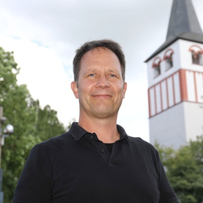 Ein Mann, im Hintergrund ein Kirchturm.