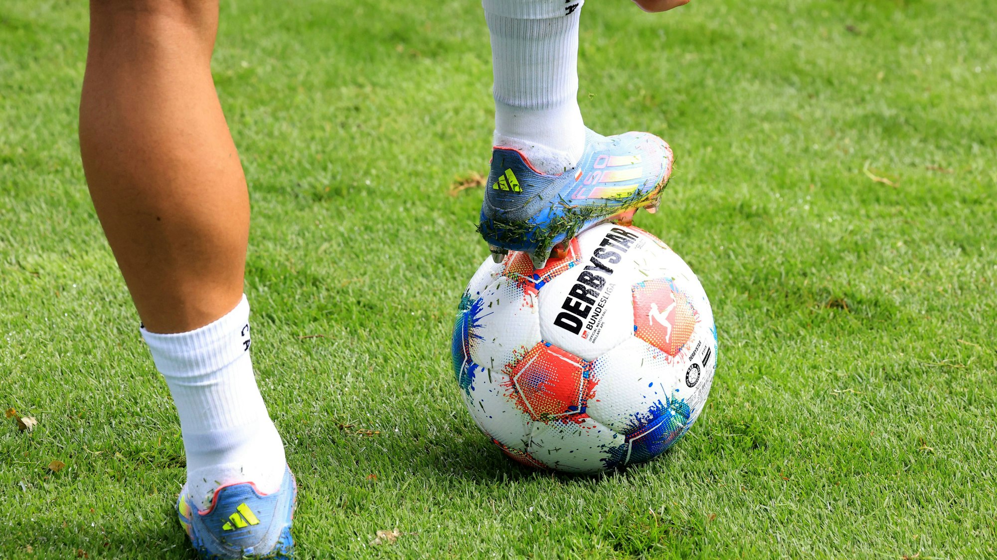 Ein Spieler der 2. Bundesliga steht zum Anstoß bereit – der bunte Derbystar-Ball wartet auf den ersten Kick.