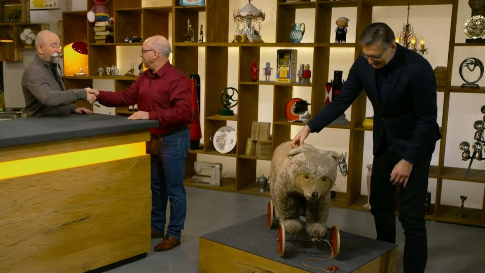 Experte Detlev Kümmel (r.) nimmt den Stoffbären bei „Bares für Rares“ unter die Lupe.
