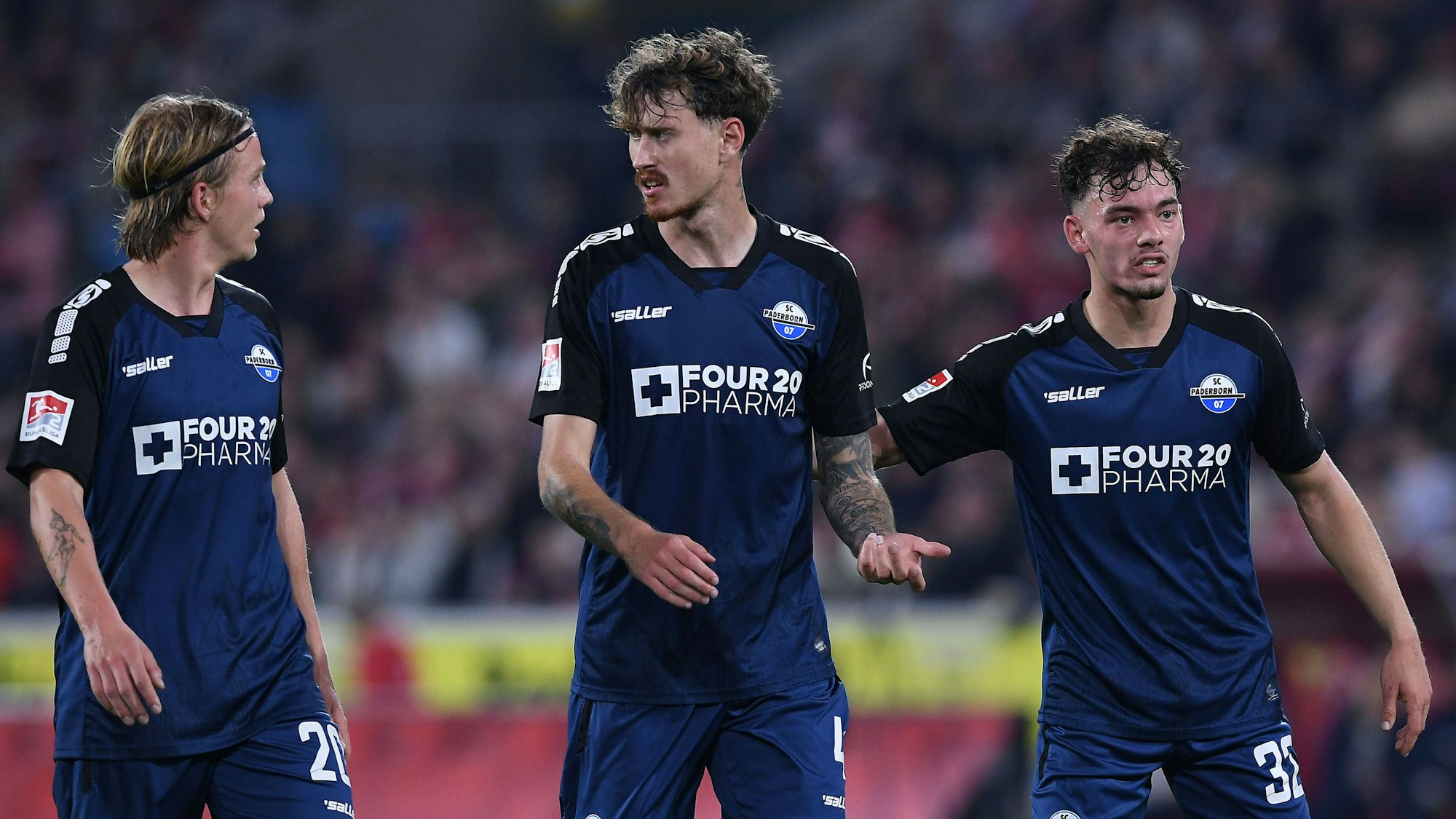 Felix Götze (l.), Calvin Brackelmann (m) und Aaron Zehnter Paderborn stehen in Köln beim Spiel gegen den FC zusammen auf dem Platz.