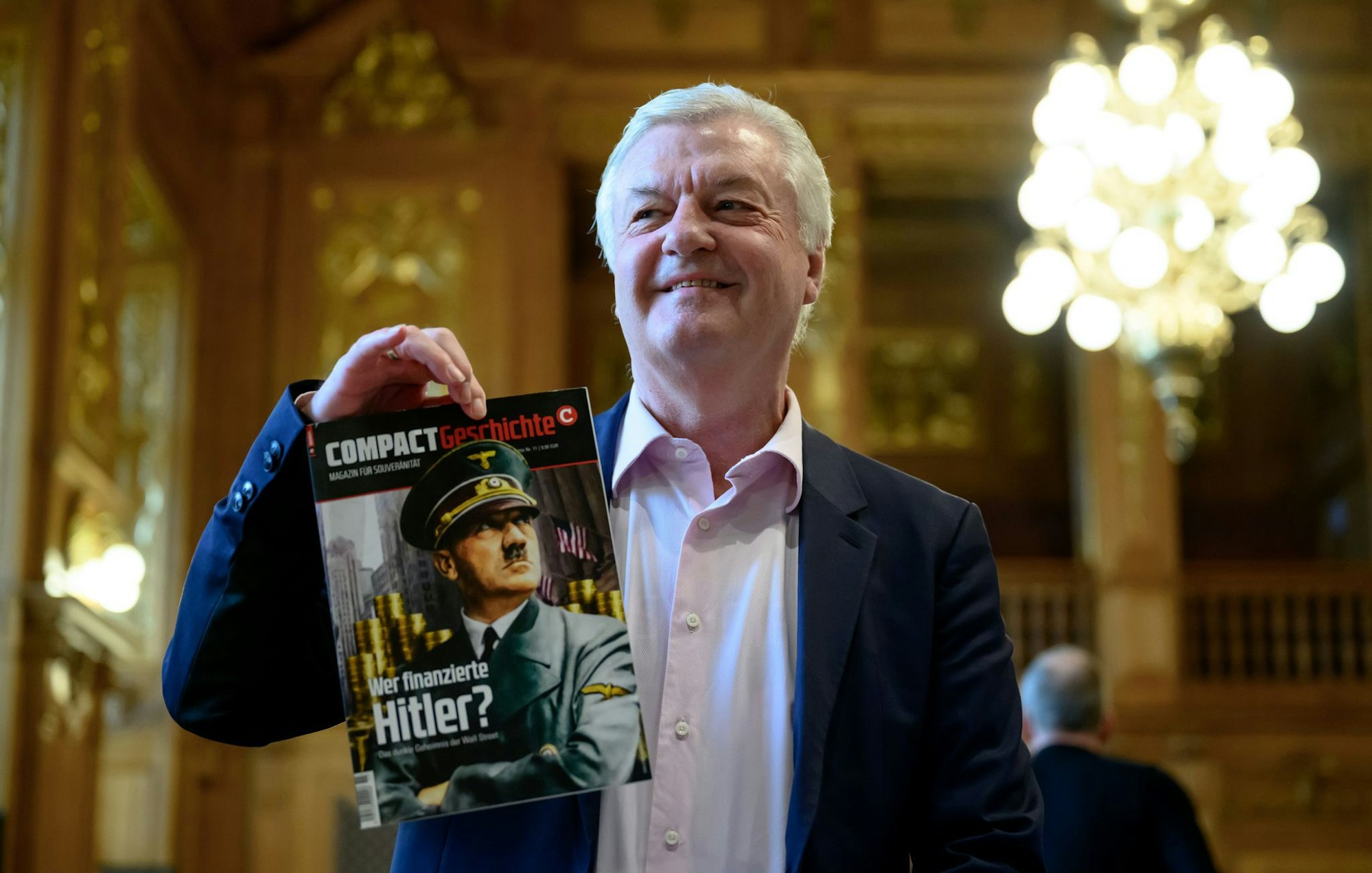 «Compact»-Chefredakteur Jürgen Elsässer hält im Bundesverwaltungsgericht in Leipzig eine Ausgabe seines Magazins «Compact Geschichte» in der Hand. (Archivbild)