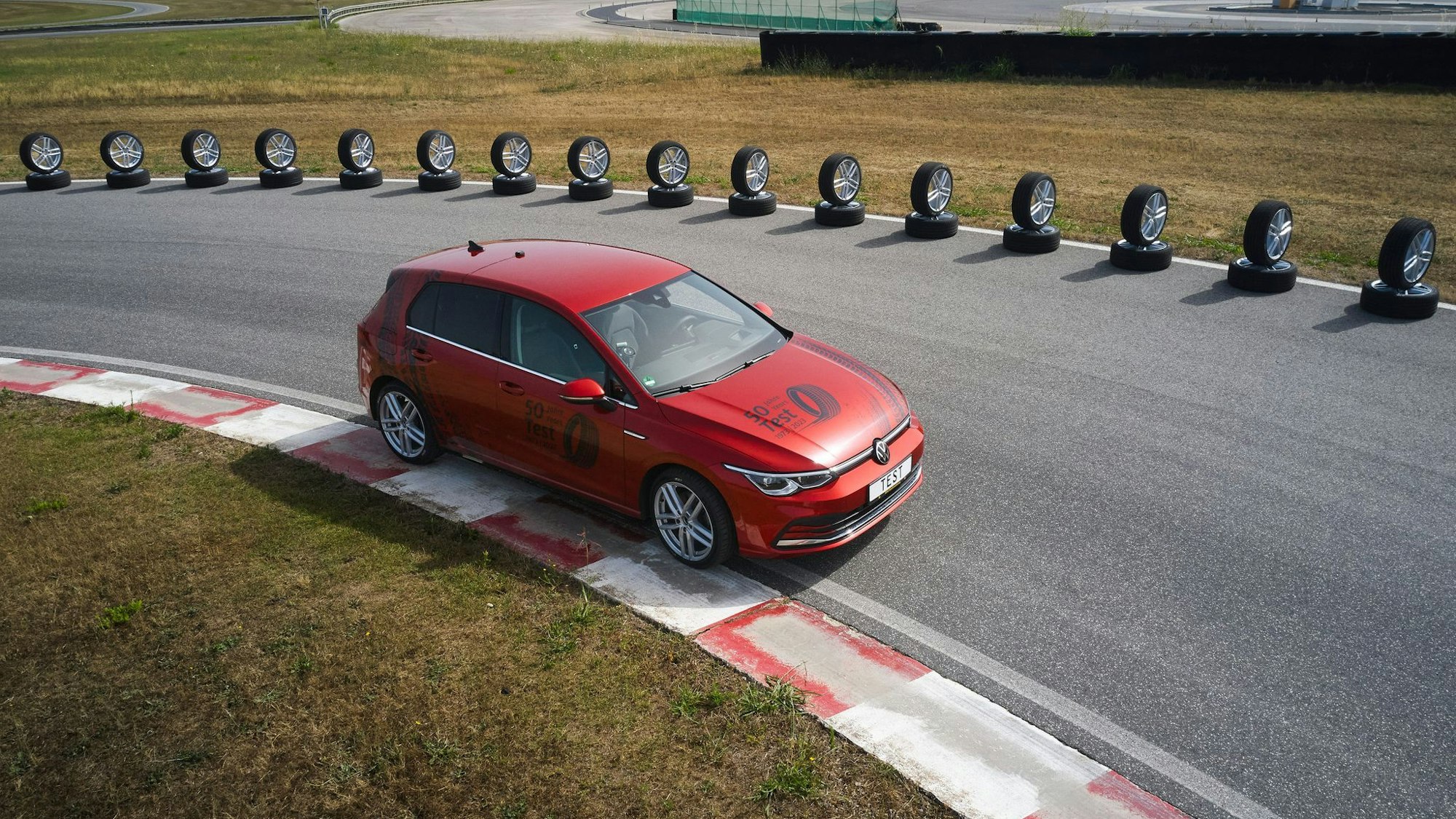 Ein rotes Auto fährt auf einer Rennstrecke.