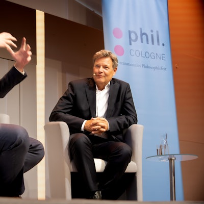 Der Satiriker Thorsten Schroeder gestikuliert mit den Händen, Robert Habeck lächelt.