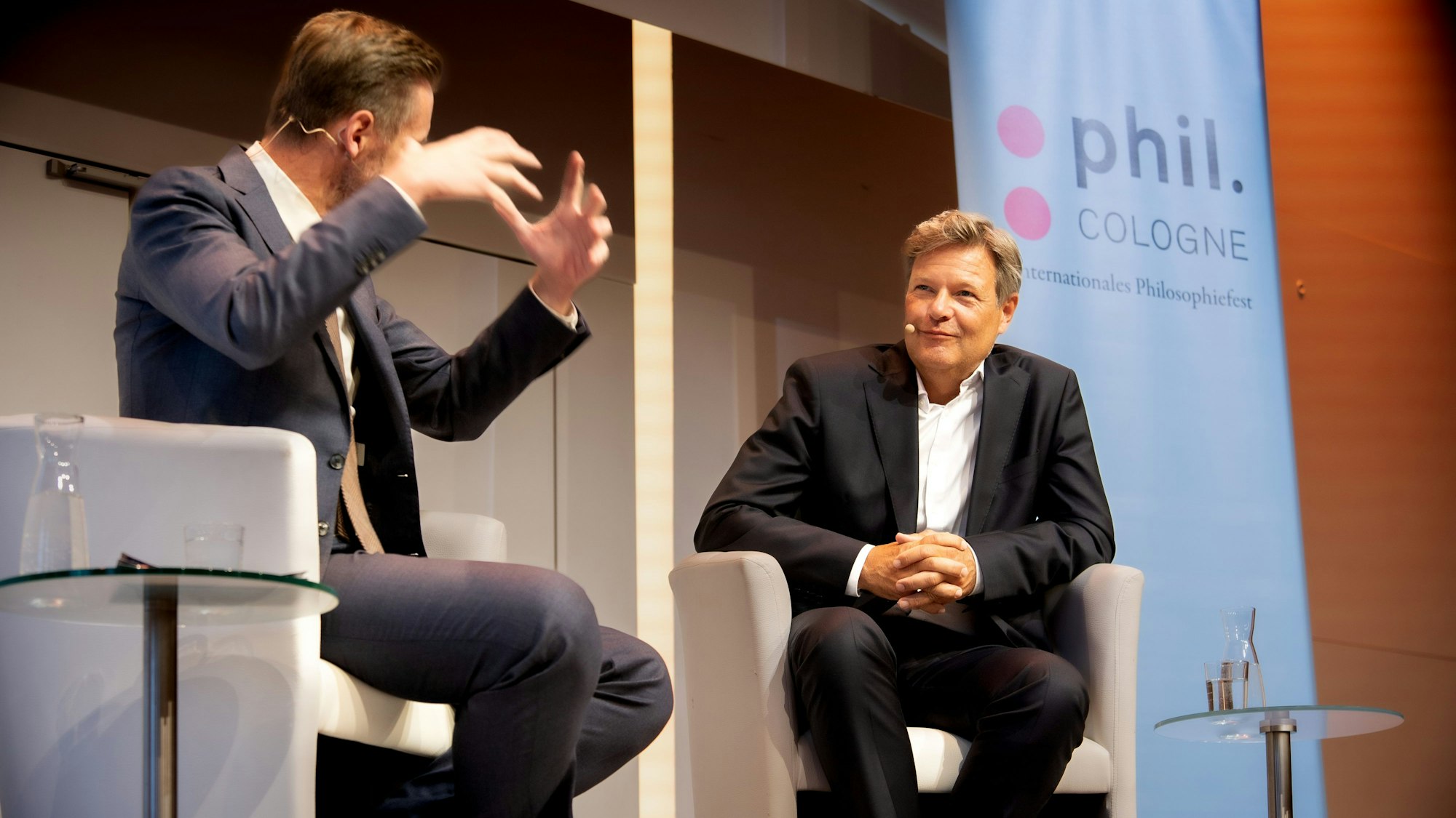 Der Satiriker Thorsten Schroeder gestikuliert mit den Händen, Robert Habeck lächelt.