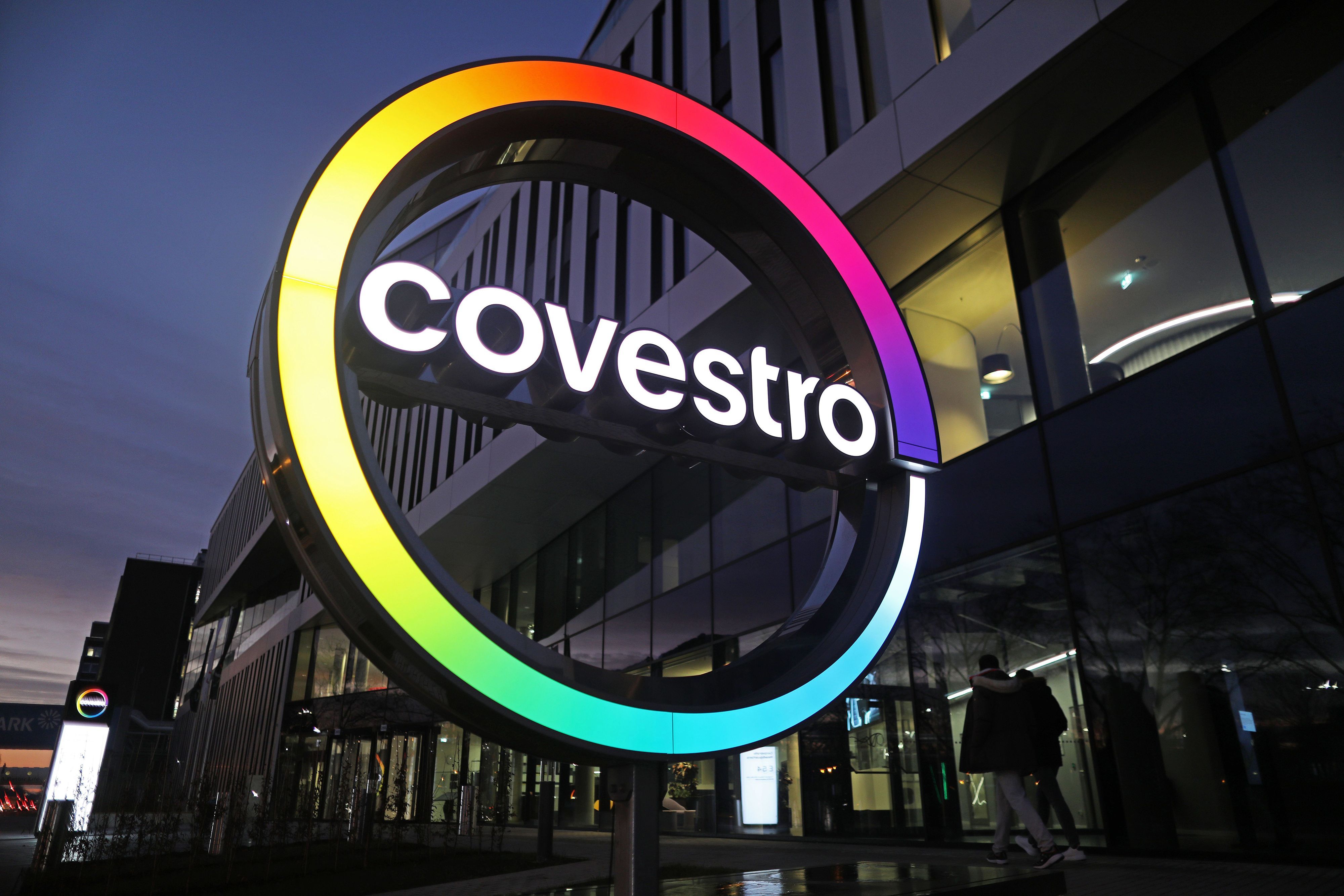 Das Logo des Kunststoffkonzerns Covestro leuchtet vor der Unternehmenszentrale am Chempark Leverkusen.