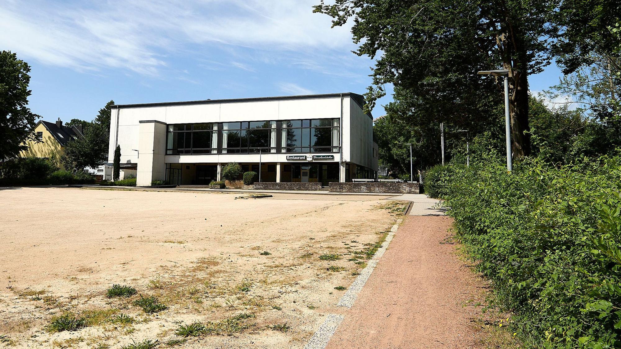 Das Bild zeigt die sanierungsbedürftige Grenzlandhalle und einen leeren Platz davor.