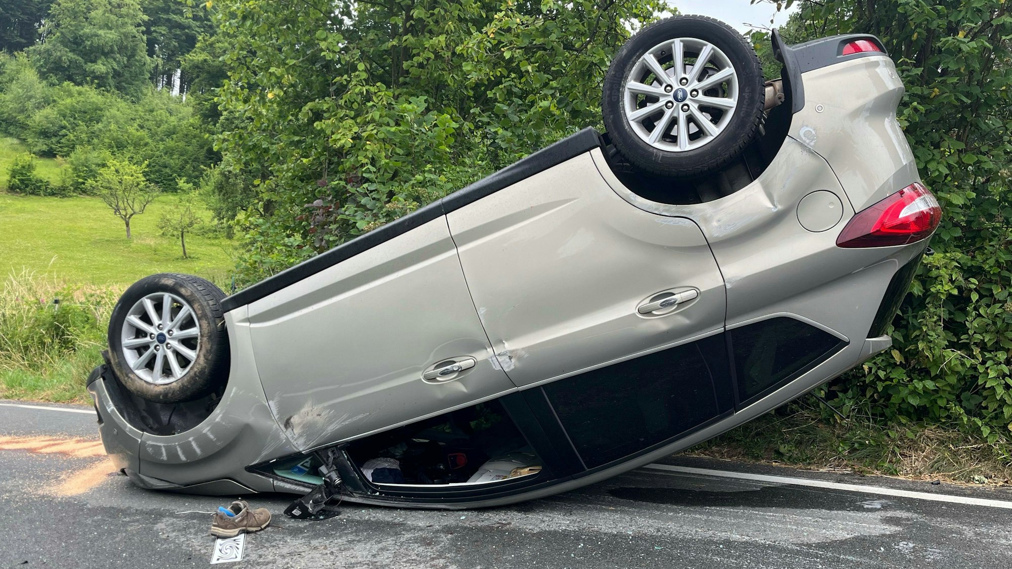 Unfallstelle in Kürten-Durhaus mit auf dem Dach liegenden Pkw