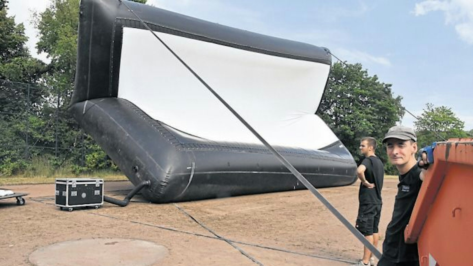 Für das Mucher Autokino hatte Michael Woll (r.) eine XXL-Leinwand aufgeblasen, für den Kirchenhof reicht eine Nummer kleiner.