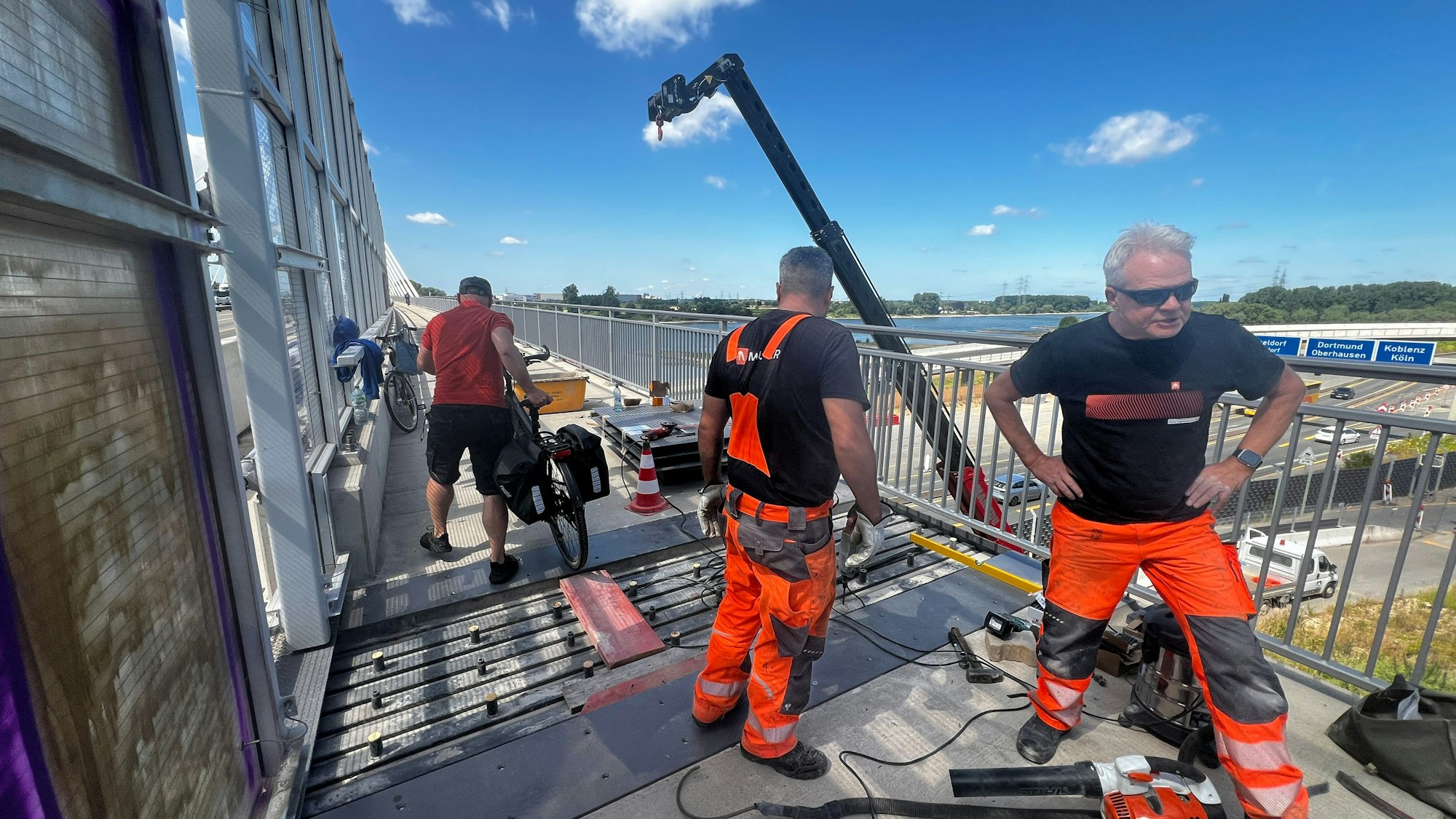 Bauarbeiter stehen auf einer Brücke.