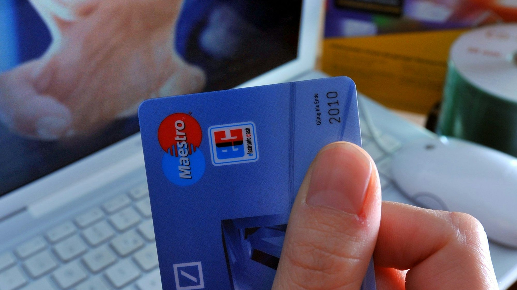 ARCHIV - ILLUSTRATION - Eine EC-Karte wird am 22.11.2008 vor den Monitor eines Computers gehalten. Sie sind jung, sie kommen aus Osteuropa und sind Teil von gut strukturierten Banden, die in Deutschland das große Geld ergaunern wollen. Ausgespähte Bankkarten-Daten, Diebstähle, Einbrüche und Enkeltrick - die zunehmende Bandenkriminalität bereitet der Polizei mehr und mehr Probleme. Foto: Hendrik Schmidt dpa/lby (zu dpa Gespräch «Bandenkriminalität ist massives Problem im Polizei-Alltag» vom 04.02.2012) +++(c) dpa - Bildfunk+++