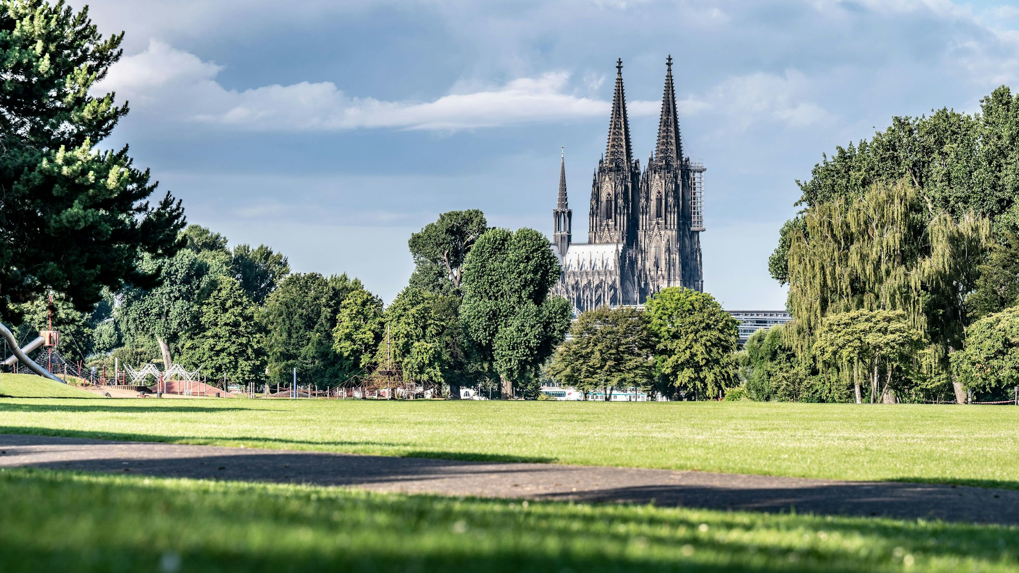 Wolkenbank und Sonnenschein im Rheinpark in Köln, im Hintergrund der Kölner Dom. (Archivbild)