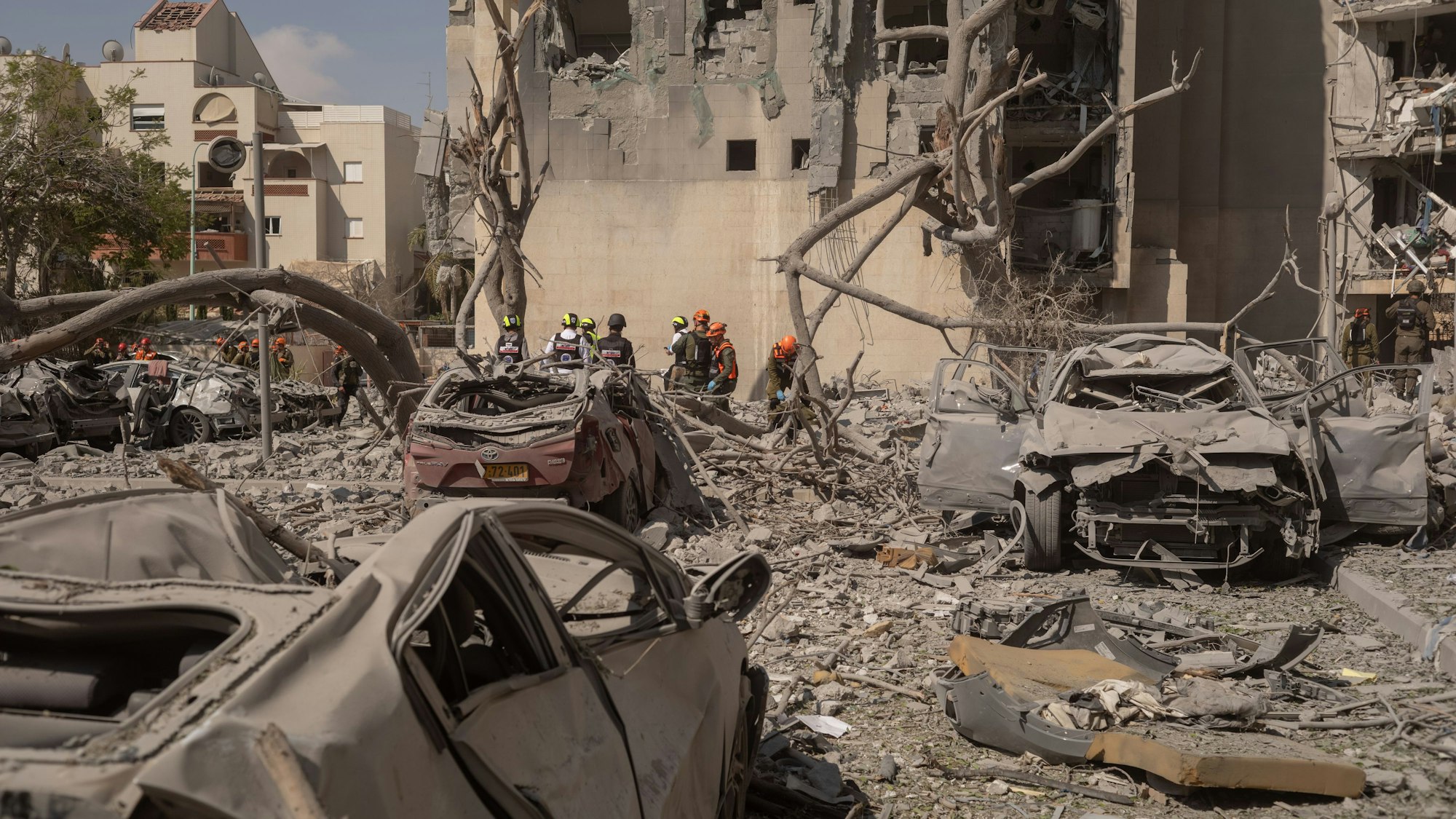 Das Bild zeigt Feuerwehrleute, die einen Ort inspizieren, an dem eine iranische Rakete eingeschlagen ist und mehrere Menschen getötet hat. Foto: Ilia Yefimovich/dpa