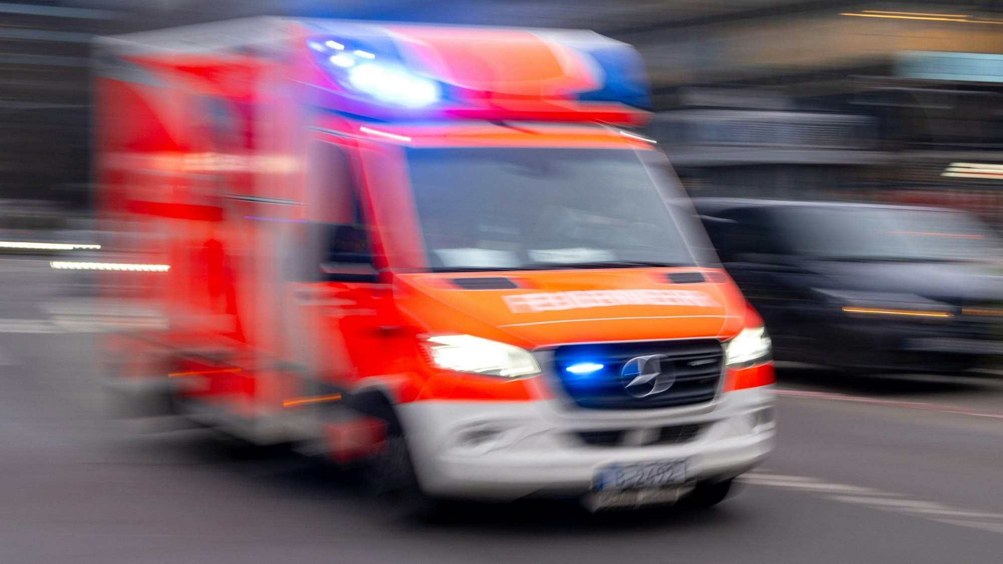 Ein Rettungswagen der Feuerwehr fährt mit Blaulicht zum Einsatz.