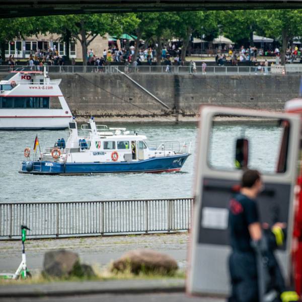 Ein Polizeiboot auf dem Rhein und ein Einsatzwagen der Feuerwehr am Ufer (Symbolfoto).